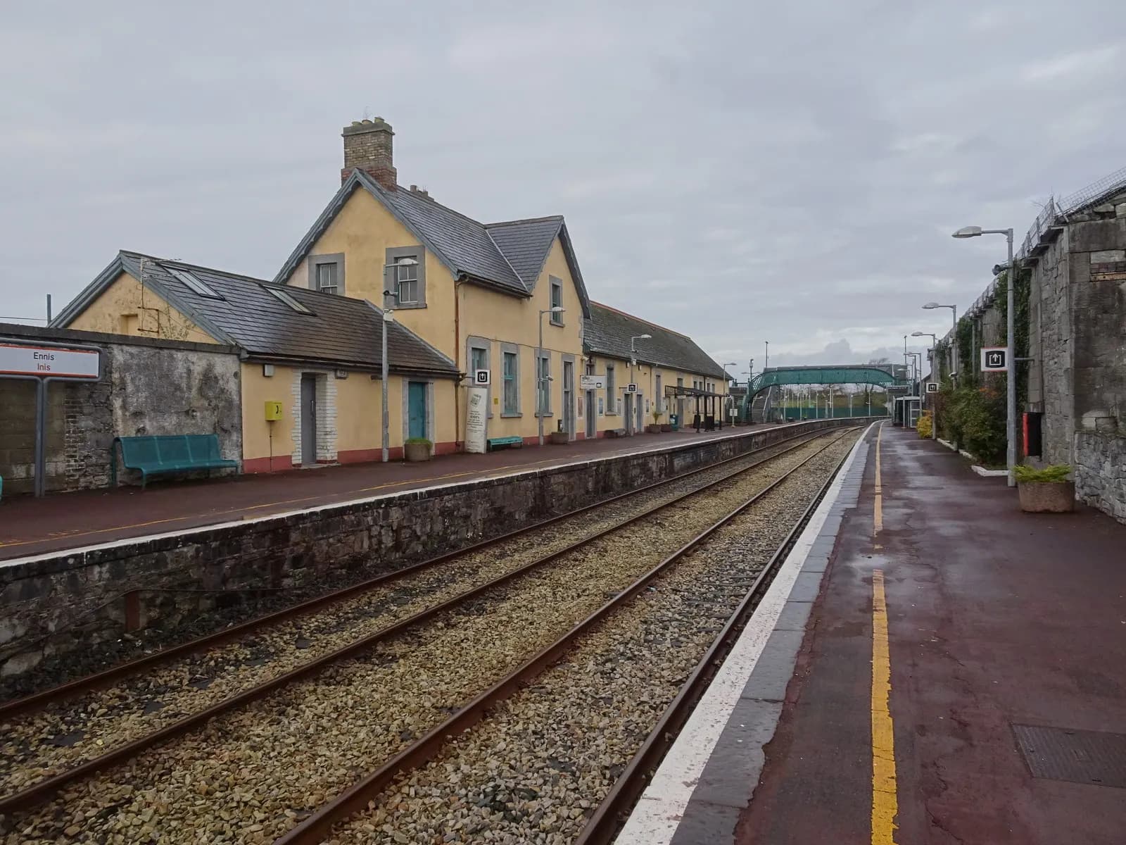 Ennis railway station in County Clare, with platforms and tracks beneath an overcast sky.