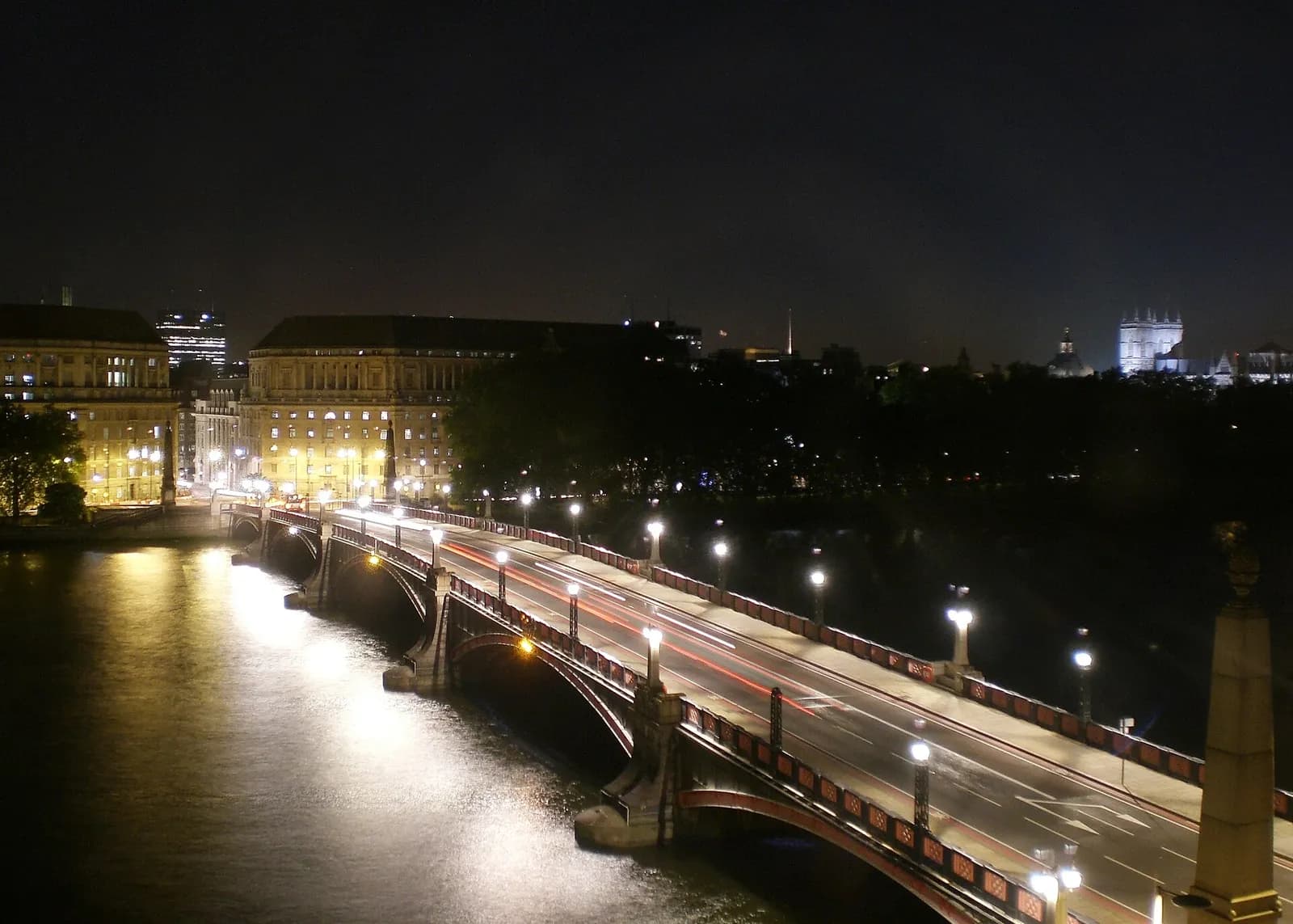Thames House and Lambeth Bridge illuminated at night in London.