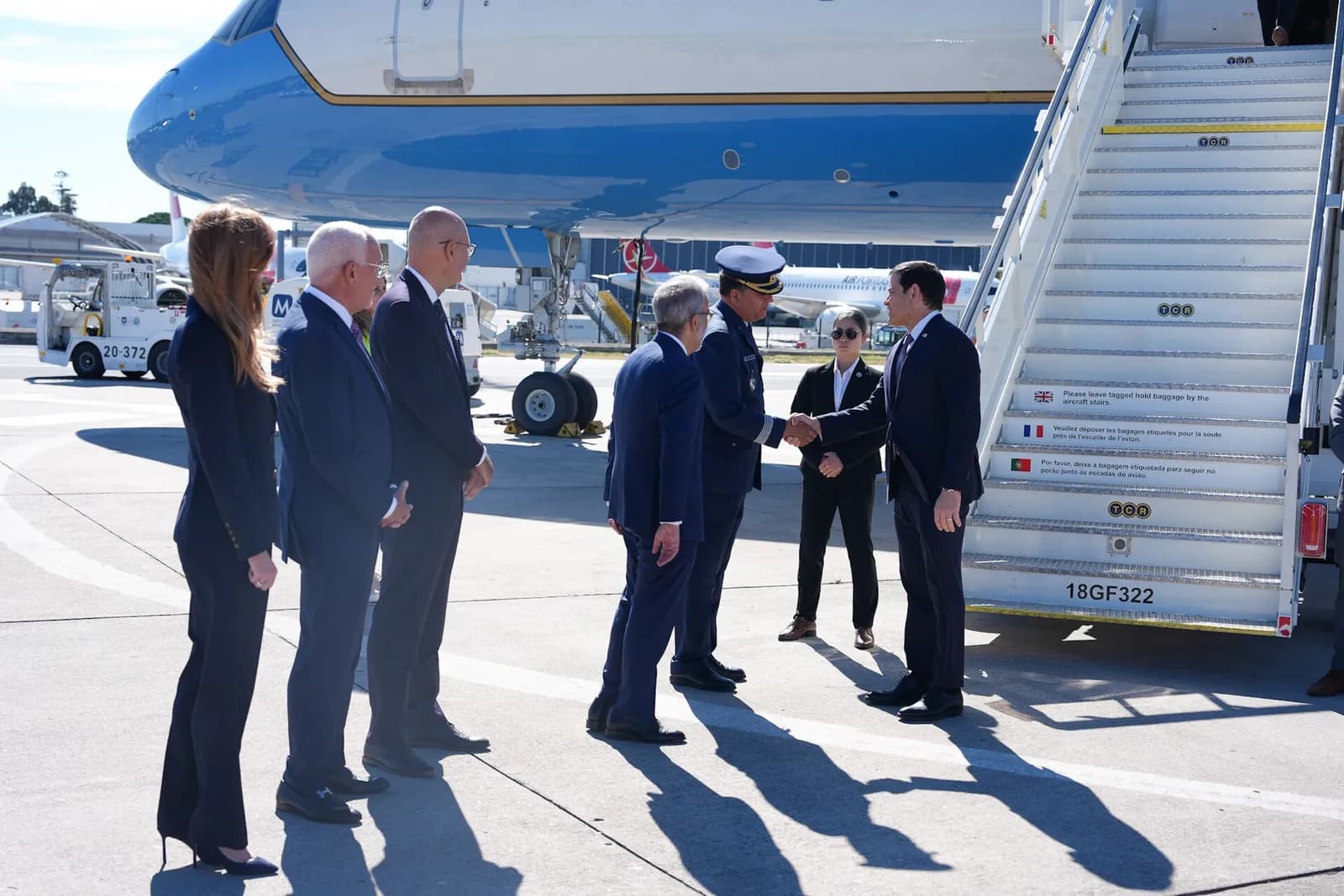 U.S. Secretary of State Marco Rubio arrives in Lisbon beside an aircraft.