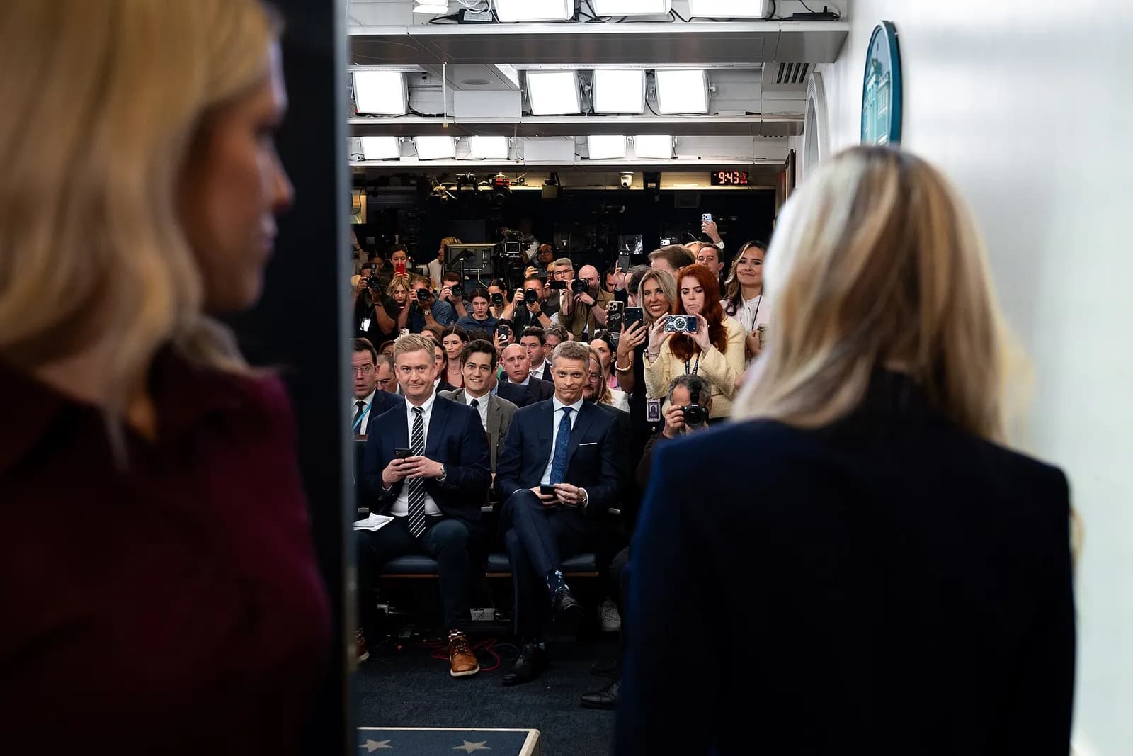 Katie Zacharia is seen from behind facing seated reporters during a White House press briefing.