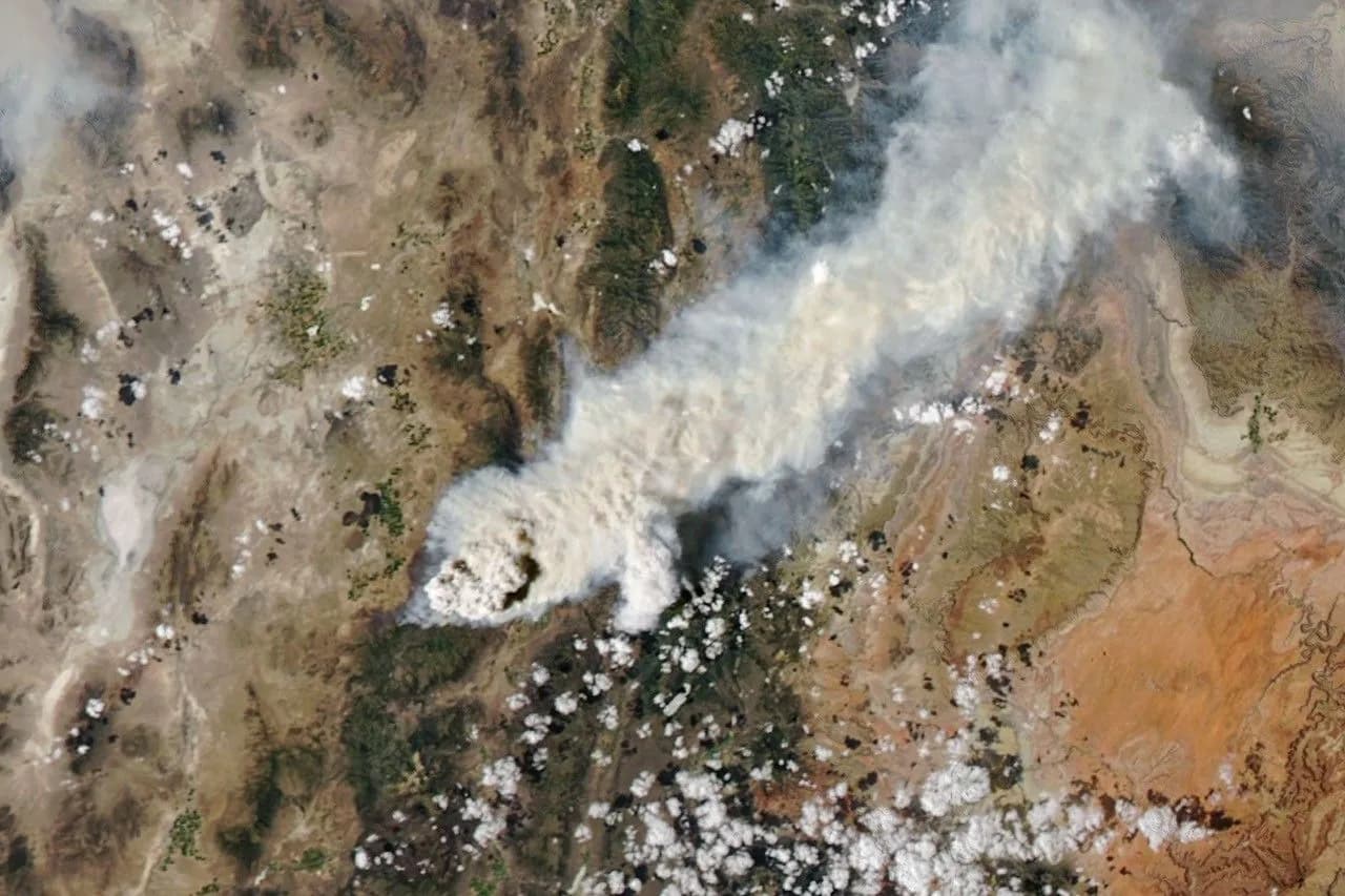 Two satellite views of smoke and a tall cloud rising from a Utah wildfire, one in natural color and one showing cloud-top temperatures