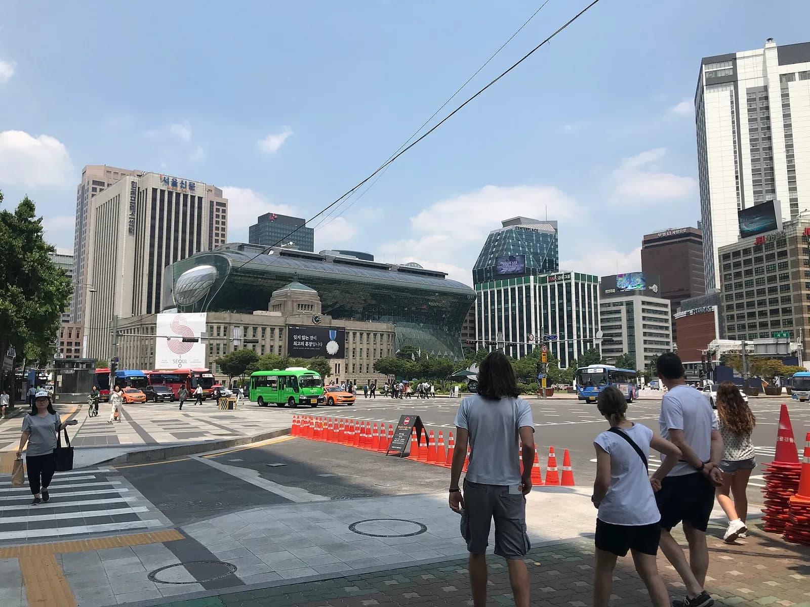Seoul City Hall’s glass building rises behind the older stone city hall, beside City Hall Plaza.
