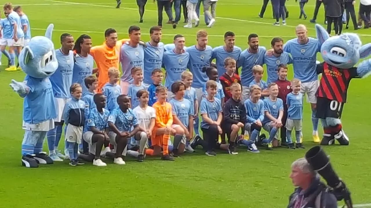 Manchester City players pose with mascots before a match in October 2022