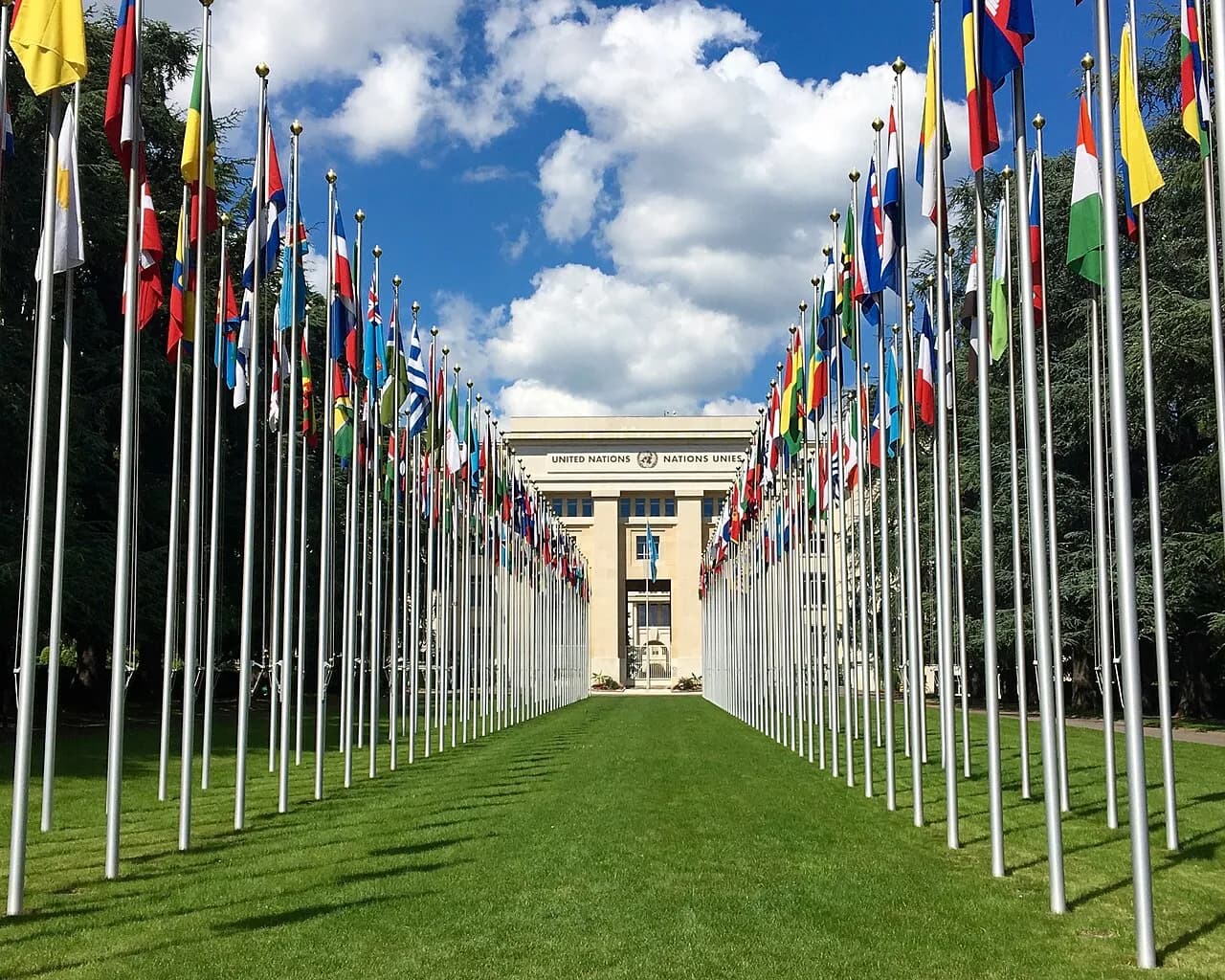 Flags line a walkway in front of the Palais des Nations in Geneva