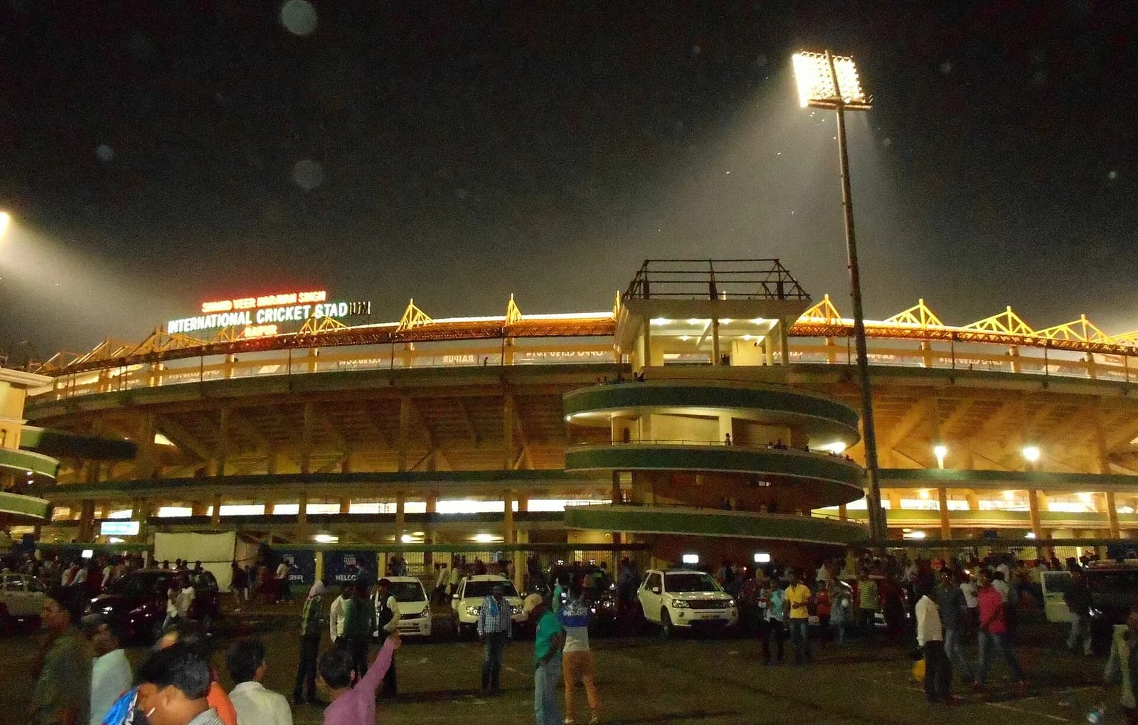 Shaheed Veer Narayan Singh International Cricket Stadium illuminated at night in Raipur, India.