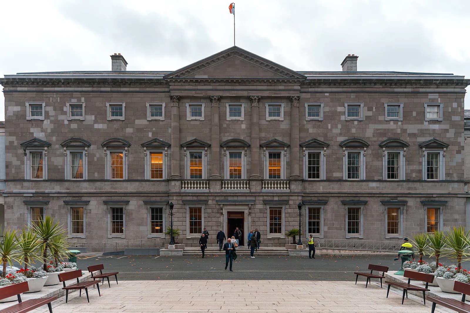 The front façade of Leinster House in Dublin, with the Irish flag flying above the building.
