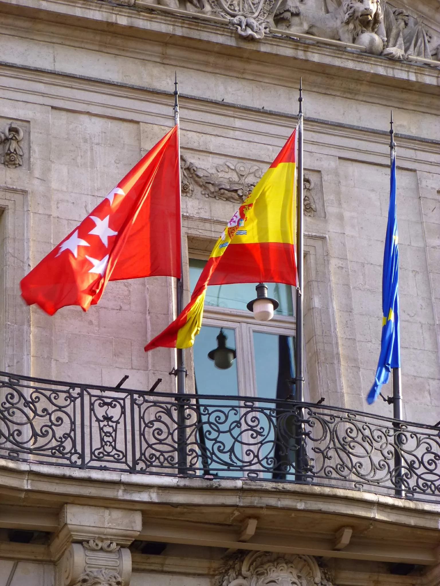 Detail of the Real Casa de Correos at Puerta del Sol in Madrid, with flags above its balcony.