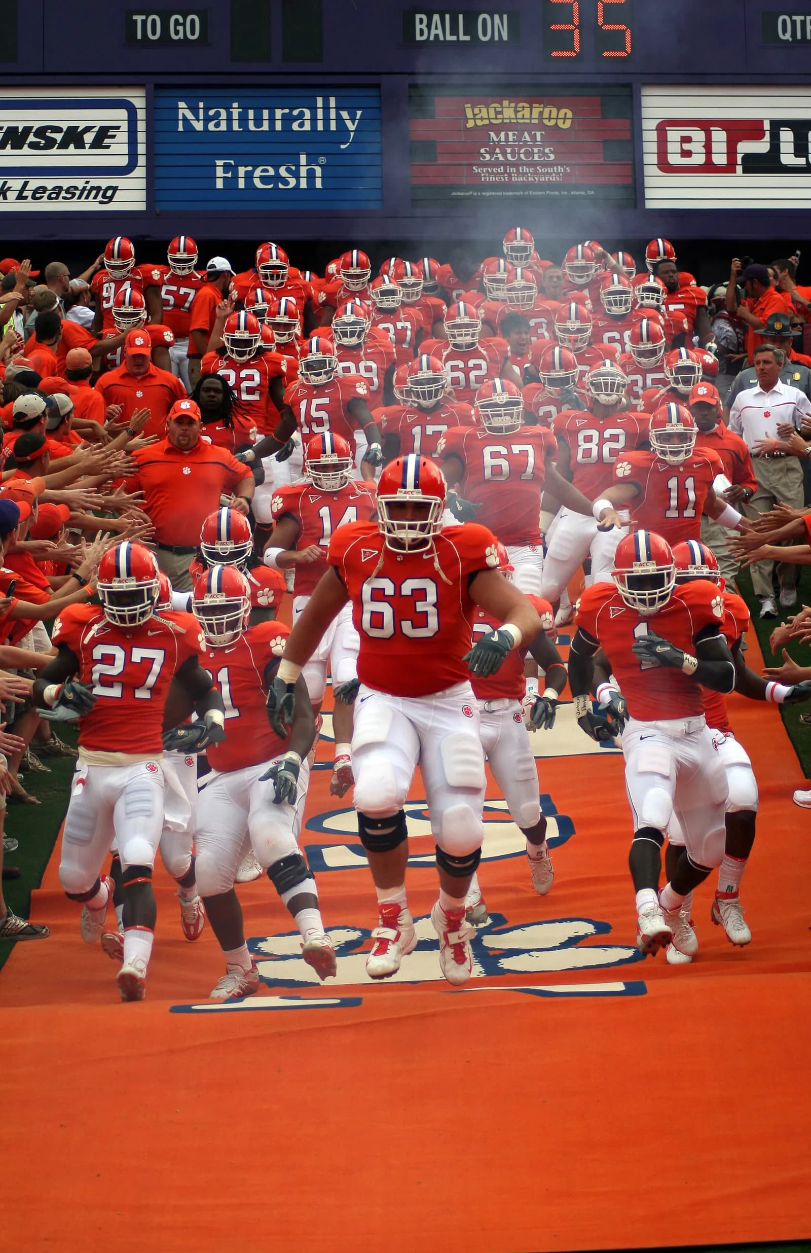 Clemson Tigers players run onto the field at the start of a game.