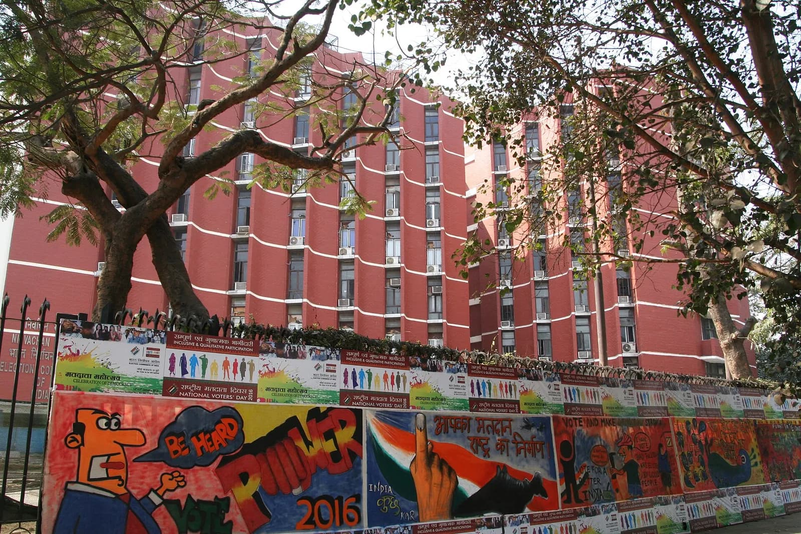 Election Commission headquarters building in New Delhi, with National Voters’ Day posters outside.