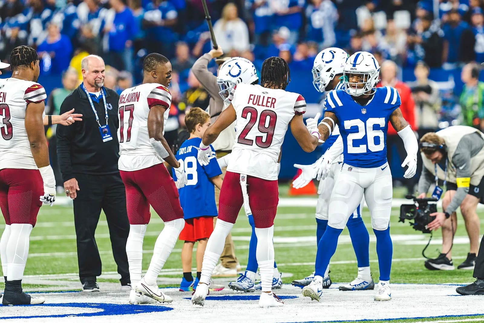 Indianapolis Colts and Washington Commanders captains shake hands before a game.