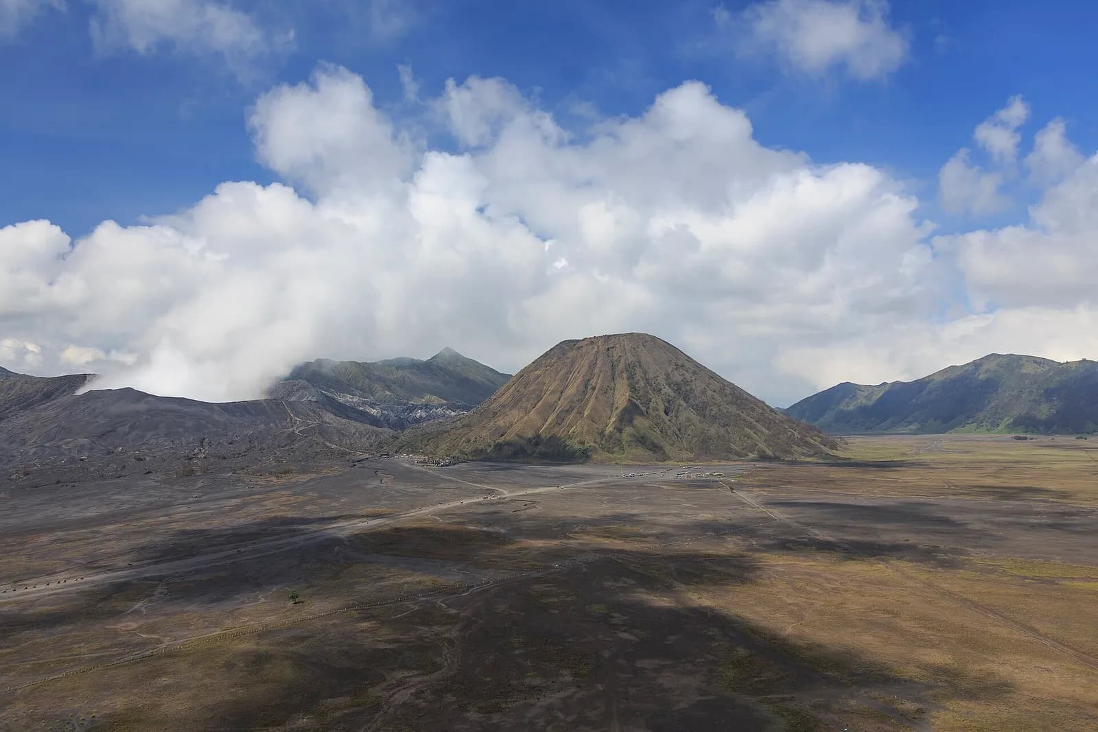 Panoramic view of the Bromo Tengger Semeru National Park caldera, with Mount Bromo, Mount Batok and Pura Tengger Temple visible.