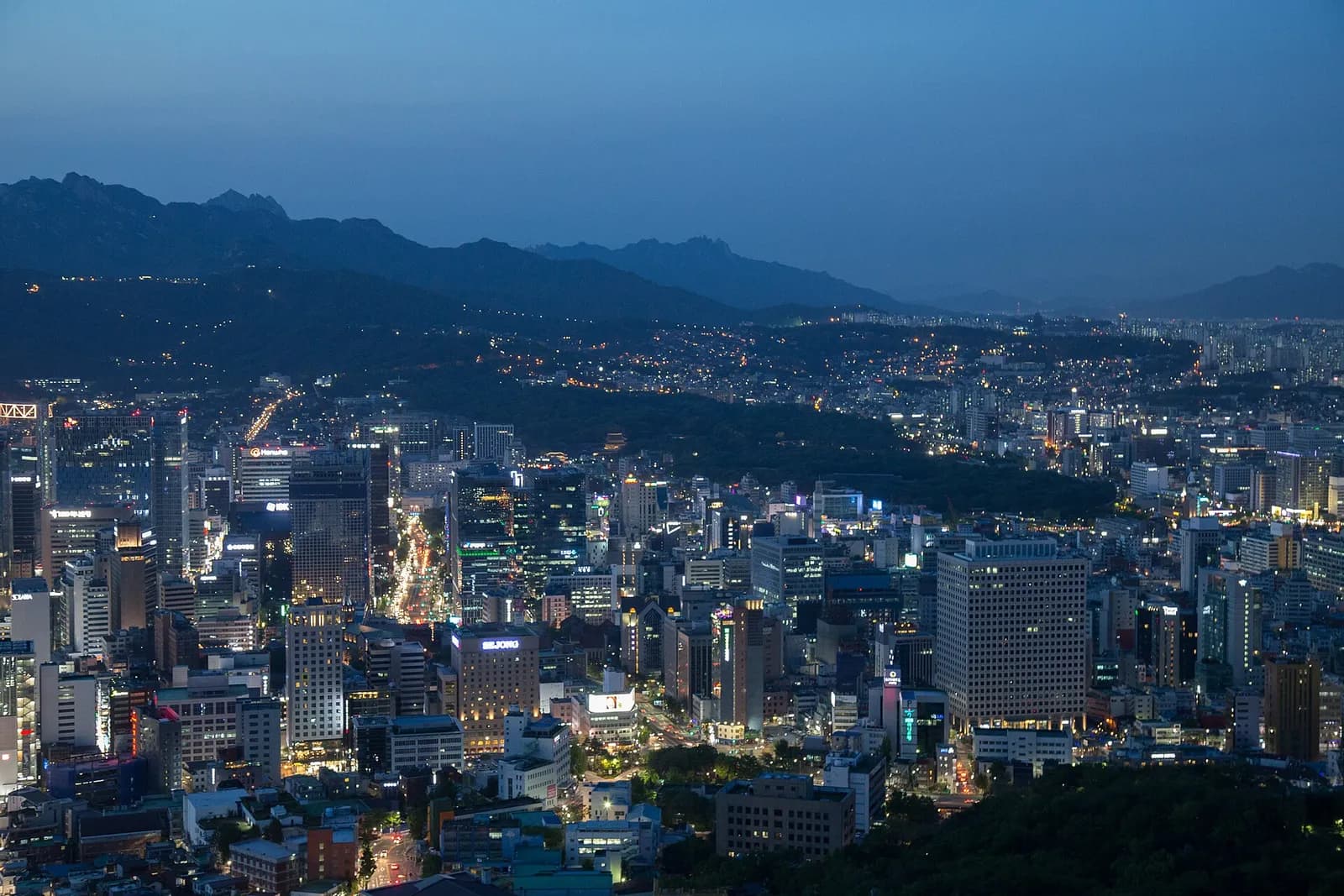 Seoul city skyline viewed from Namsan, with buildings including Jongno Tower and Changdeokgung in view.