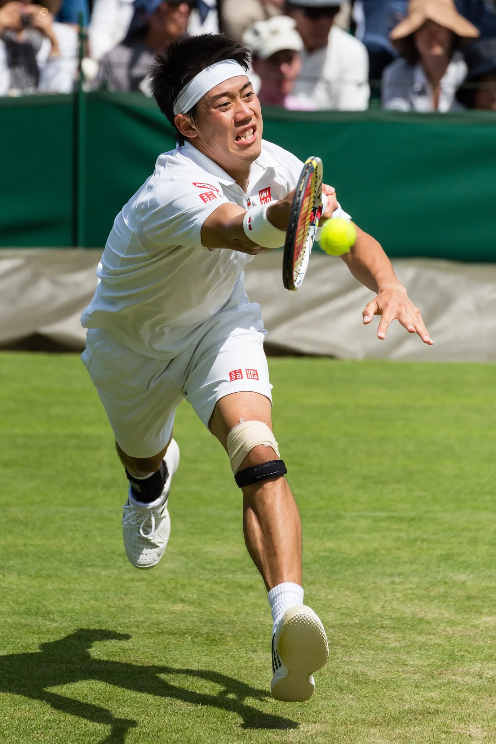 Kei Nishikori lunges toward a tennis ball during a match at Wimbledon in 2013.