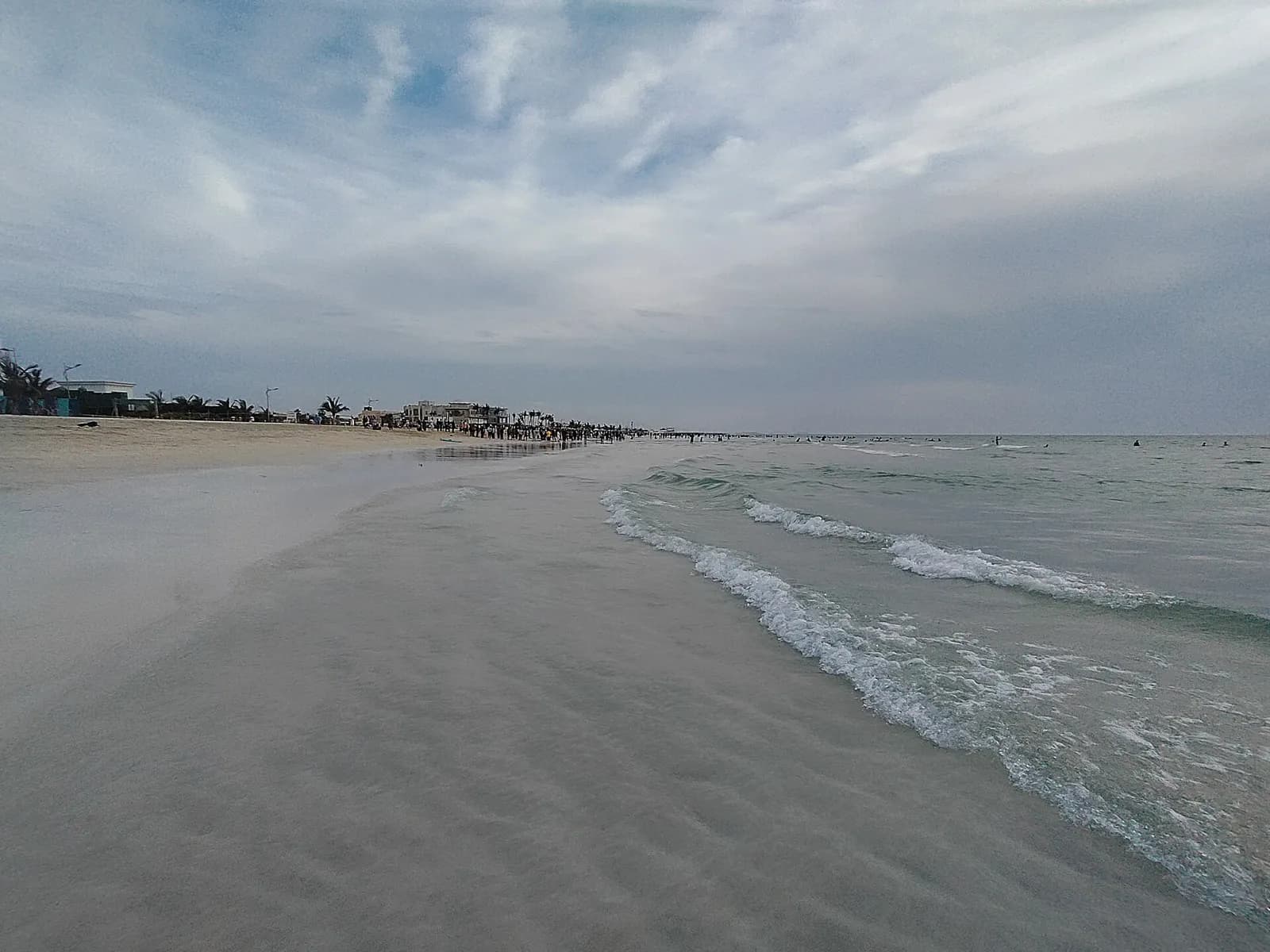 Sandy Umm Al Quwain beach and clear water at sunset.
