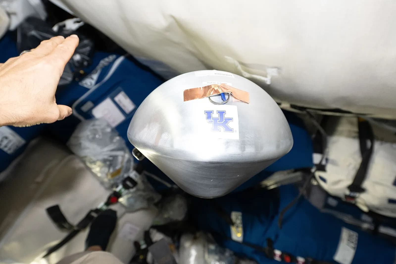 A small KREPE-3 capsule with a 3-D printed heat shield floats inside the Cygnus XL cargo spacecraft.