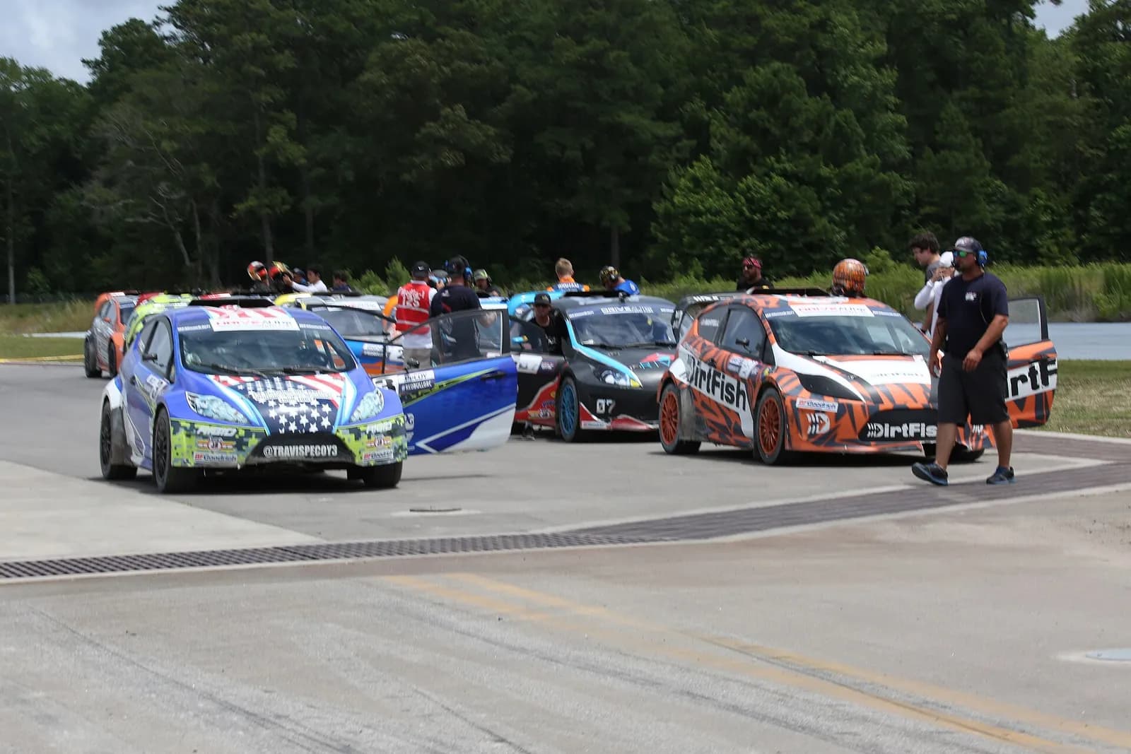 Rallycross cars line up on the track during practice.