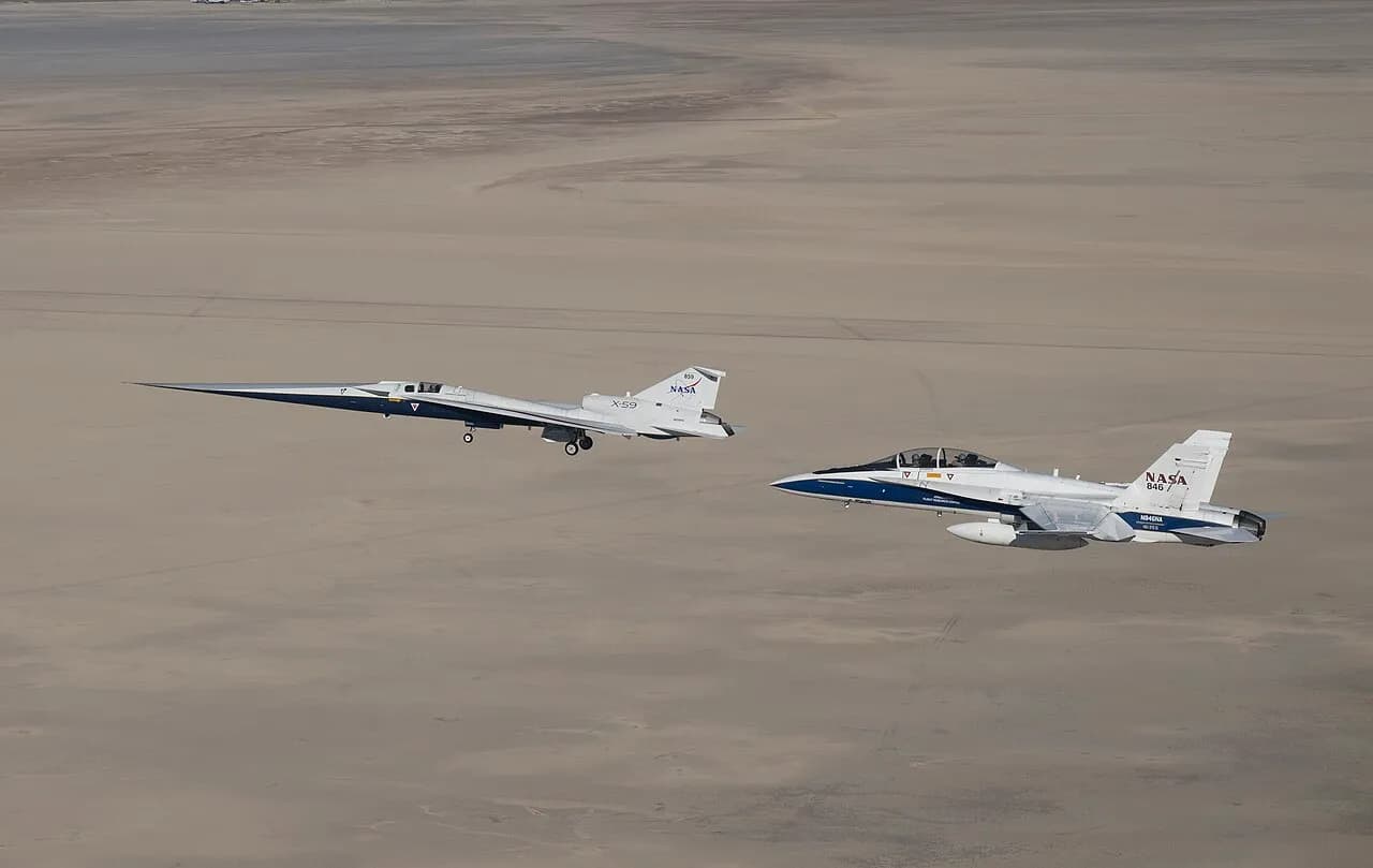 NASA X-59 research aircraft flying beside a NASA F-15 over California