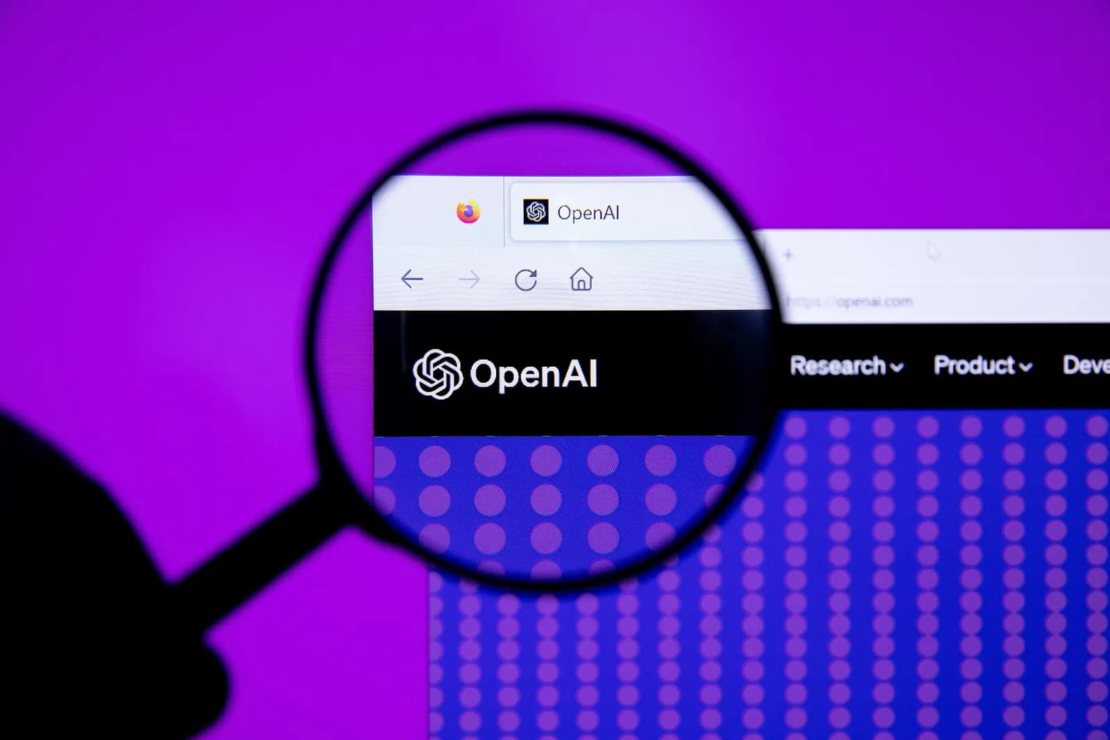 OpenAI logo photographed through a magnifying glass.