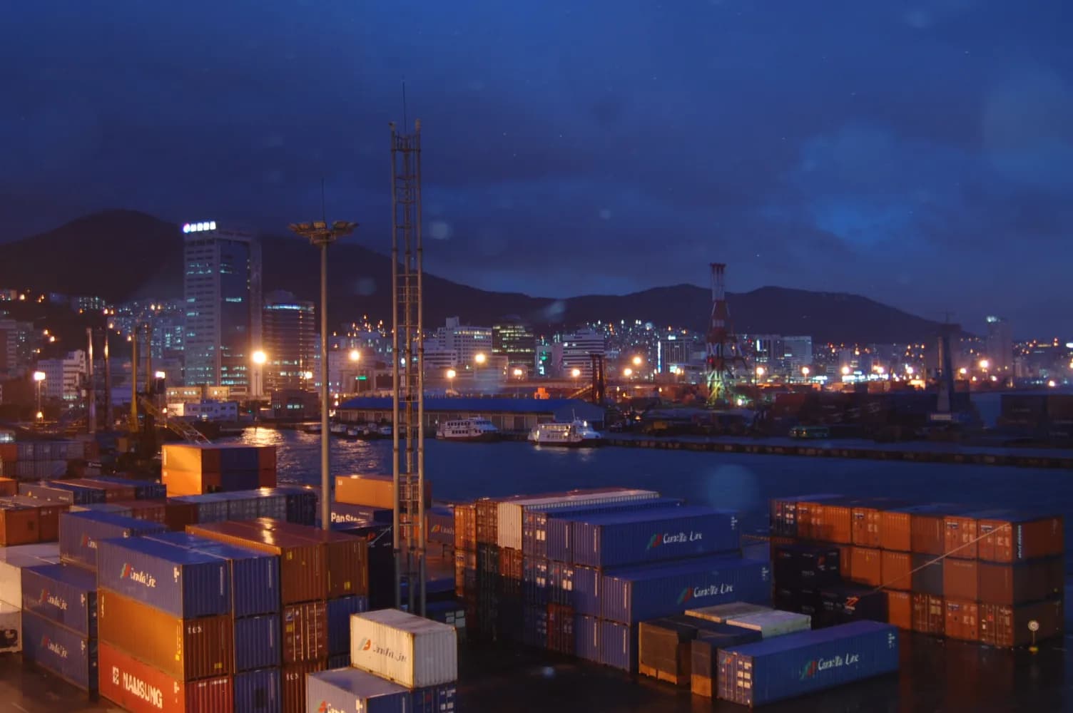 Container terminal at Busan harbour, with cargo containers and port facilities.