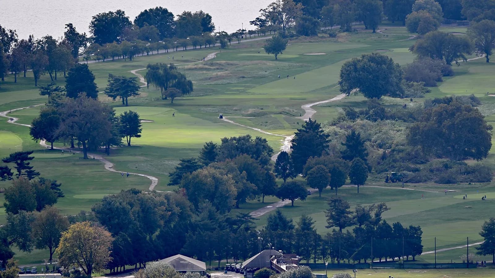 Aerial view of East Potomac Golf Links, with felled trees visible behind a green tractor.