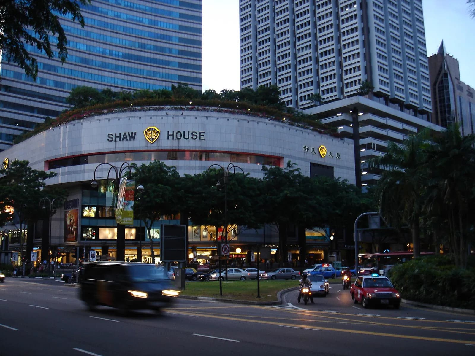 Shaw House on Orchard Road in Singapore, with high-rise buildings behind it and traffic in the foreground.