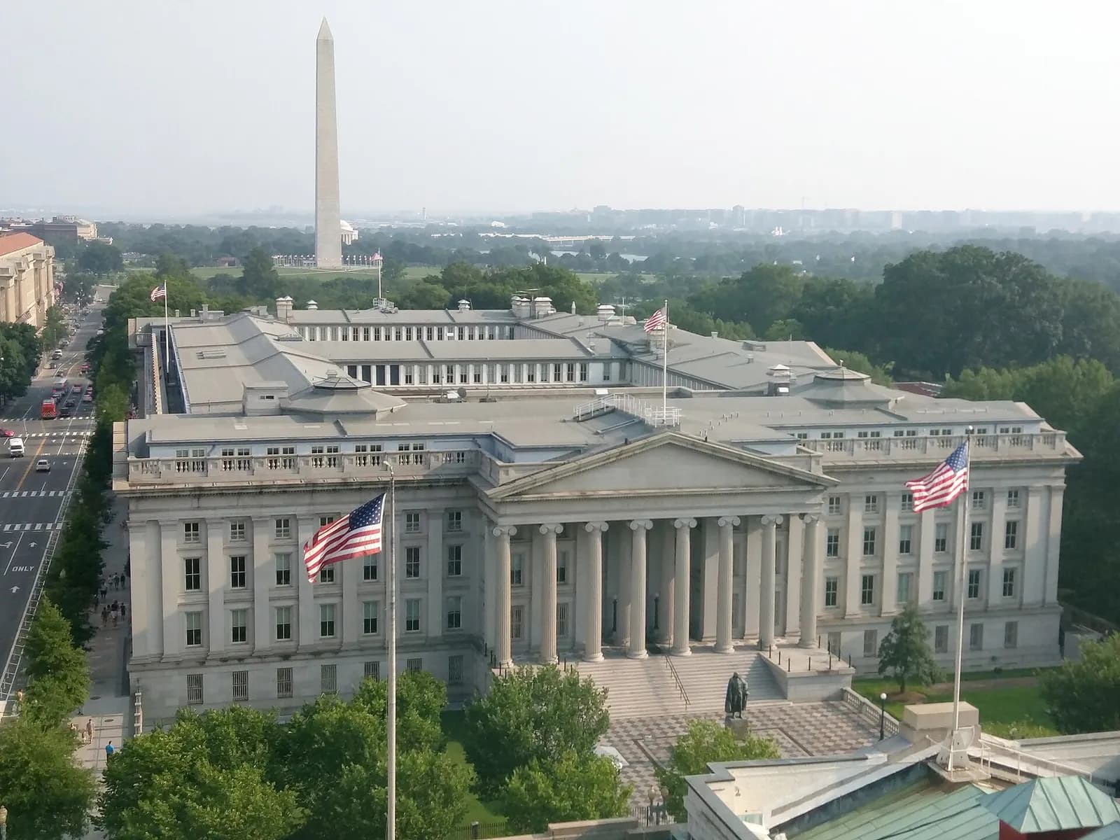 The U.S. Treasury Building in Washington, with the Washington Monument in the background.