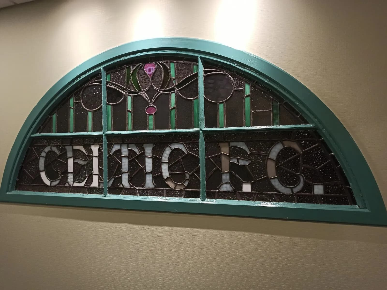 Stained-glass panel reading “CELTIC F.C.” at Celtic Park in Glasgow.