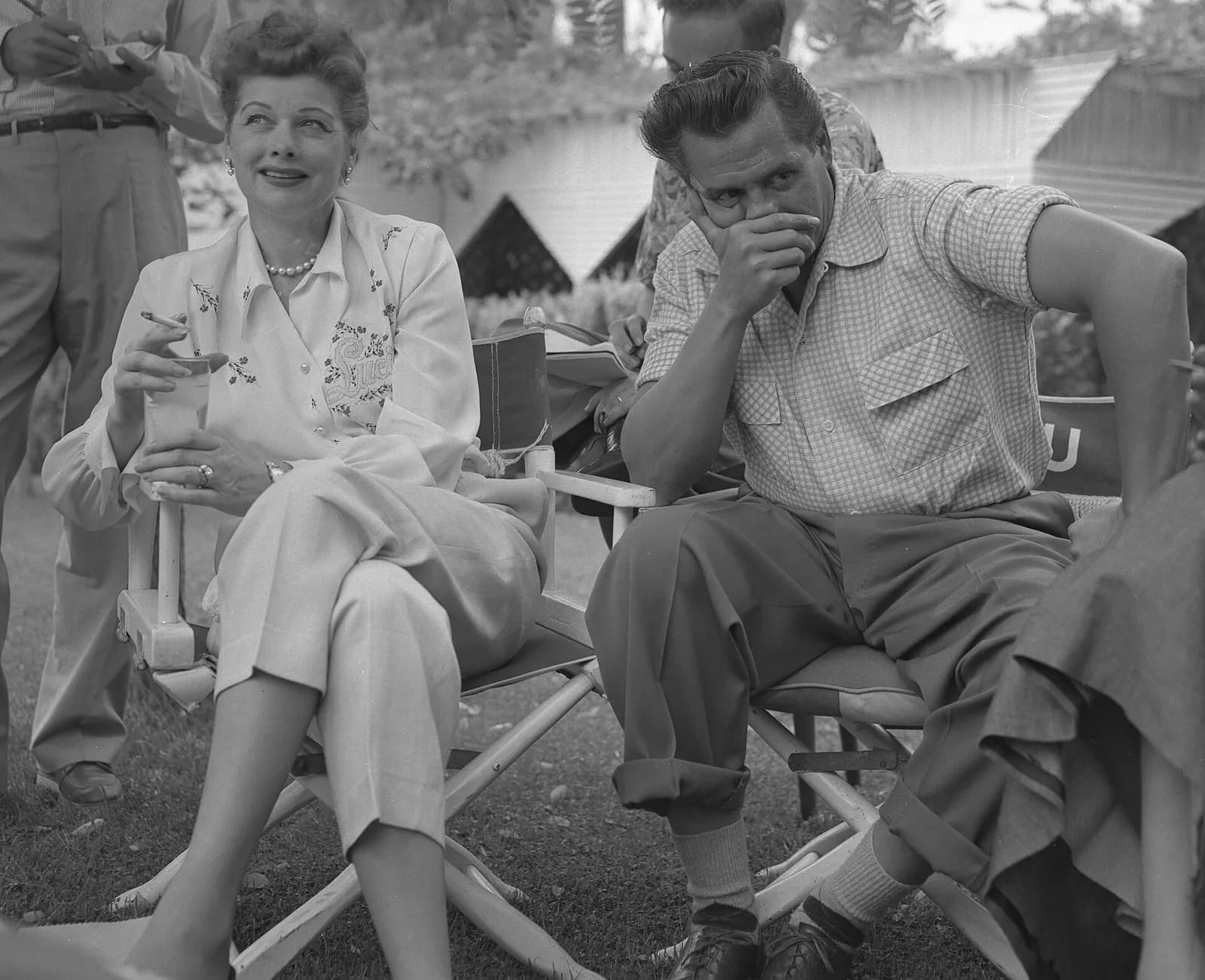 Lucille Ball and Desi Arnaz seated in directors’ chairs at a press conference.