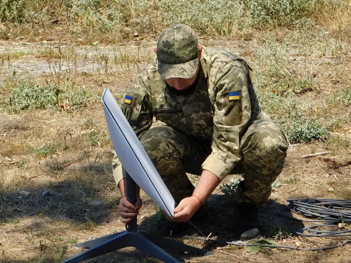 A Support Forces of Ukraine soldier installs a Starlink terminal.