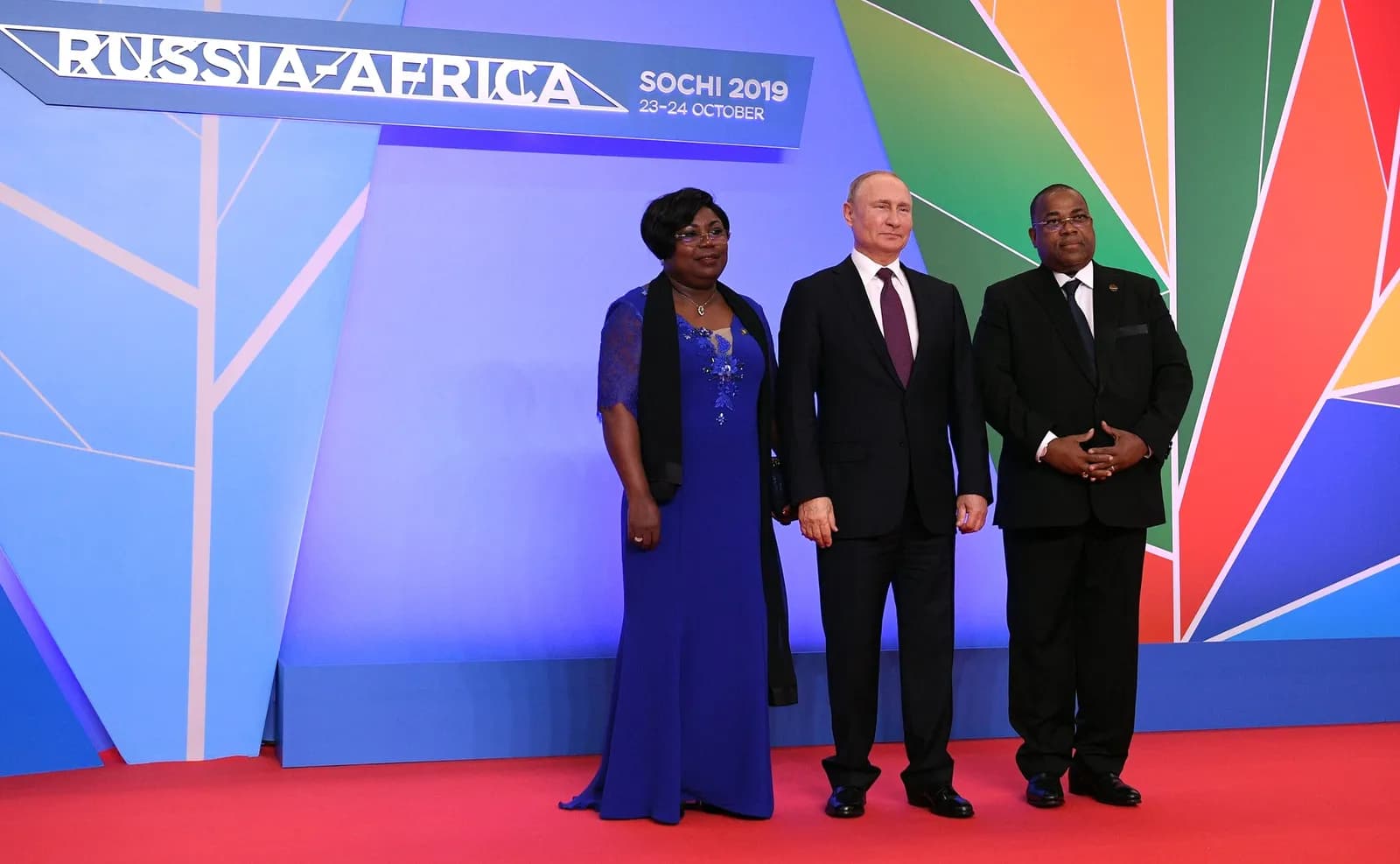 Vladimir Putin stands with Gabonese Prime Minister Julien Nkoghe Bekale and his spouse at an official welcoming ceremony.