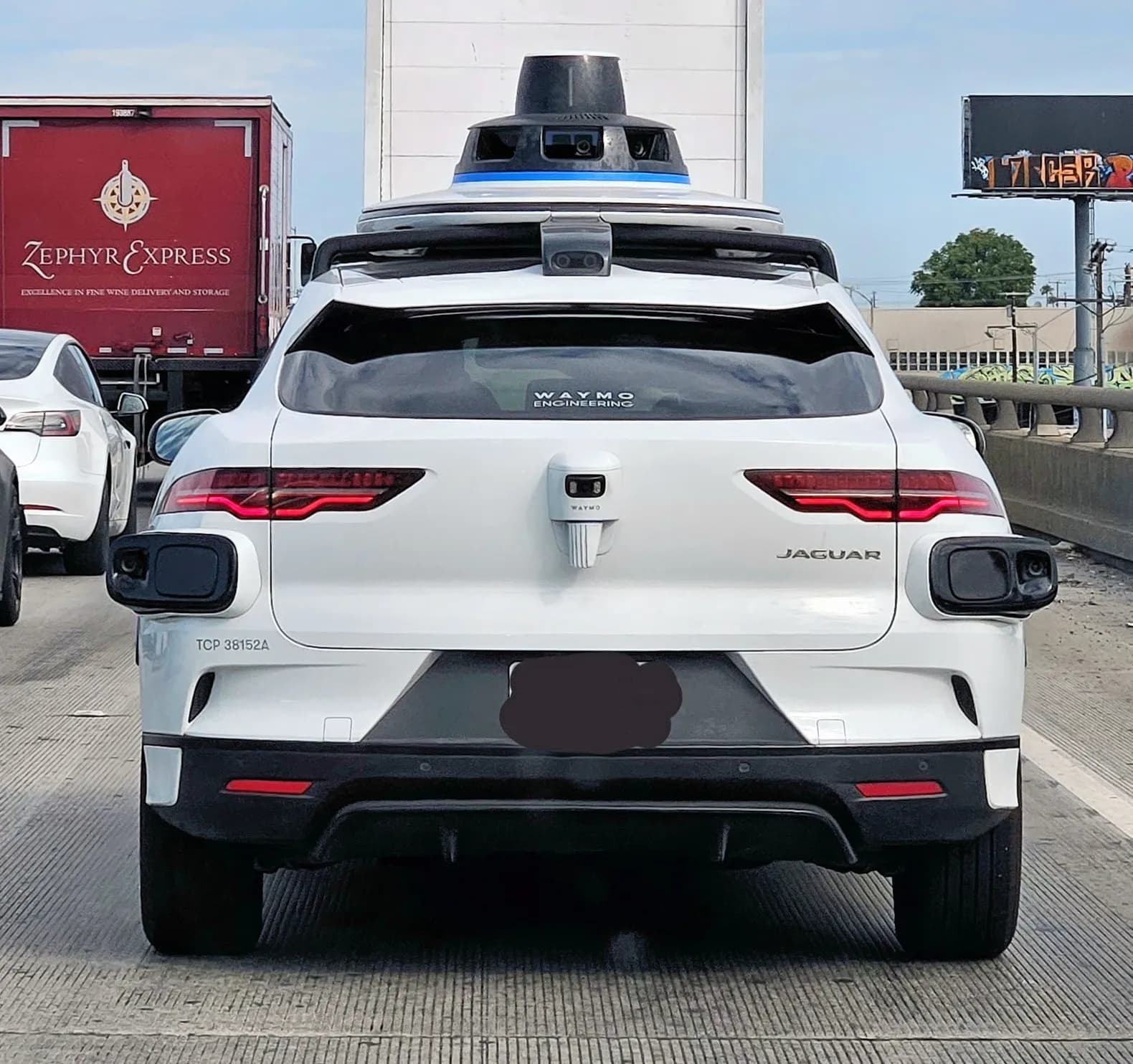 A Waymo Jaguar autonomous vehicle driving on Interstate 10 in downtown Los Angeles.
