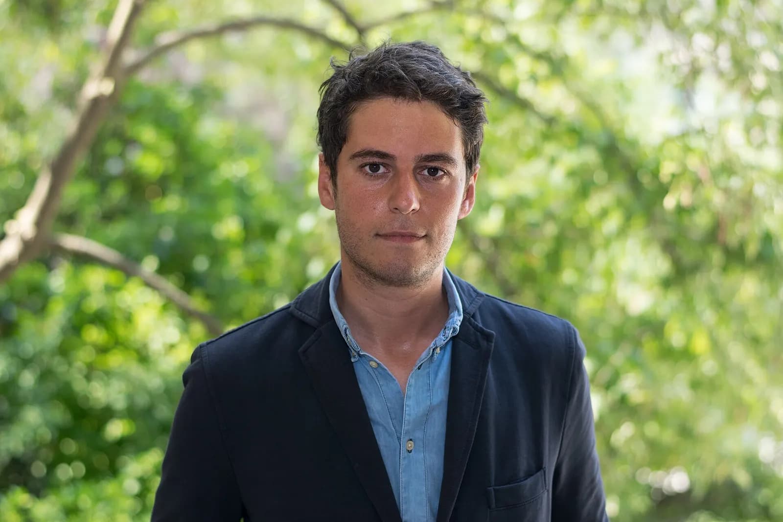 Gabriel Attal standing in the garden of the Quatre Colonnes at the Palais Bourbon in Paris.
