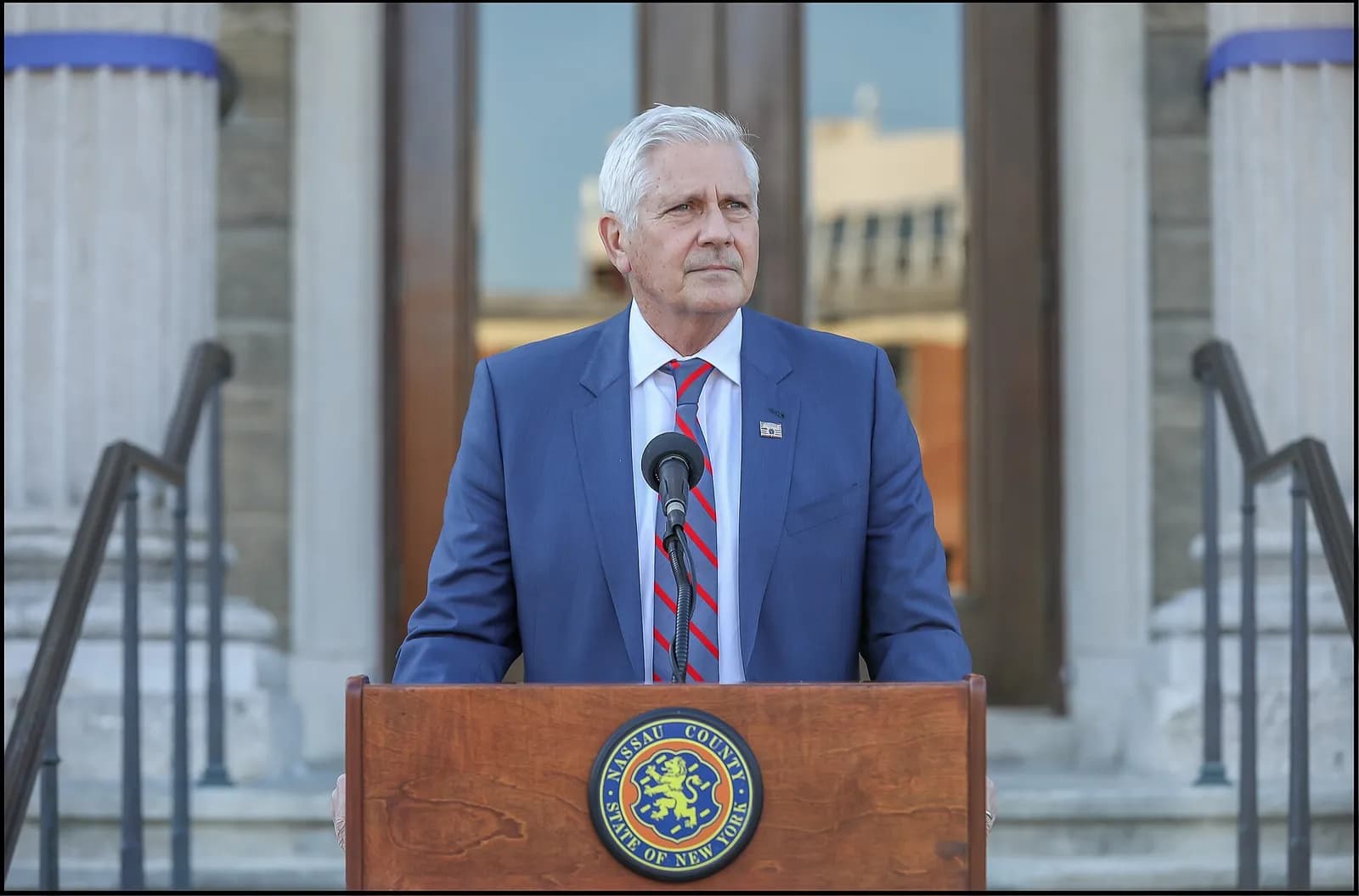 Bruce Blakeman speaks at a podium in Mineola, New York.