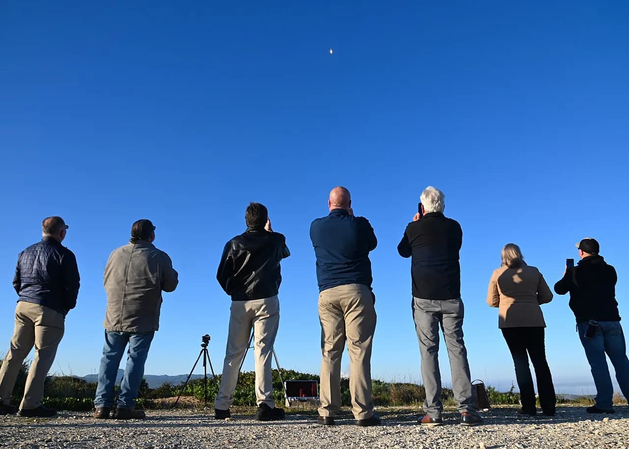 Spectators watch a Falcon 9 rocket launch at Vandenberg Space Force Base.