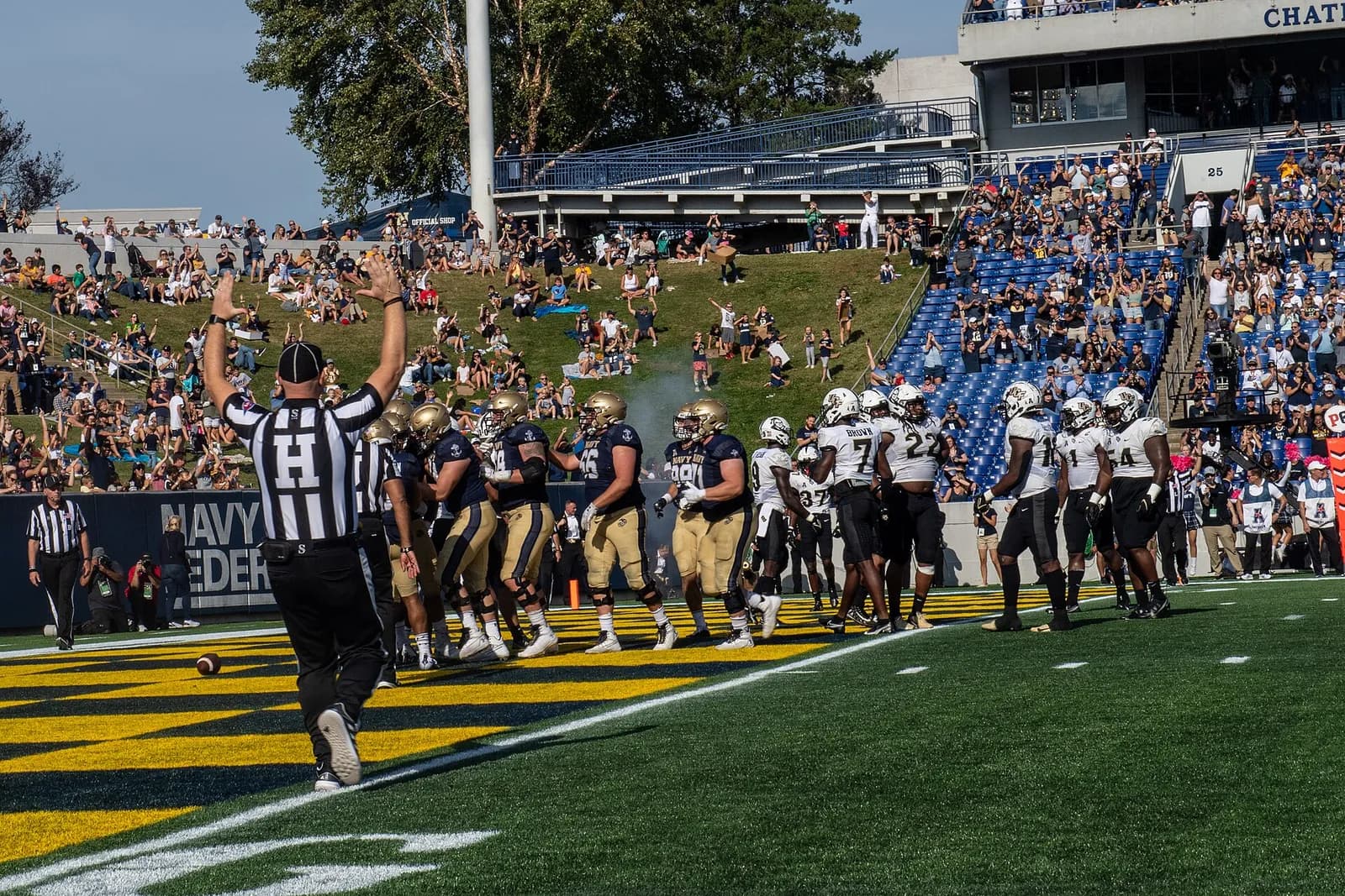 UCF Knights and Navy Midshipmen players on the field during a football game in Annapolis.