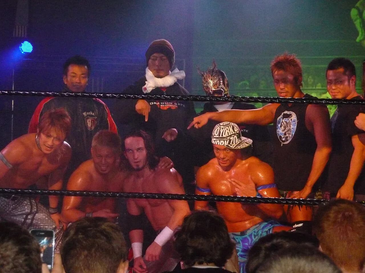 PAC poses with eight other Dragon Gate wrestlers in a wrestling ring in Oxford in 2009.