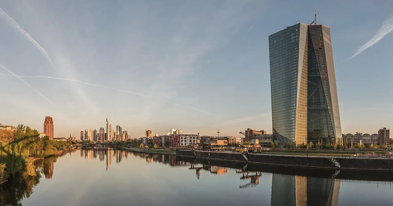 The European Central Bank headquarters beside the Frankfurt skyline at dawn.
