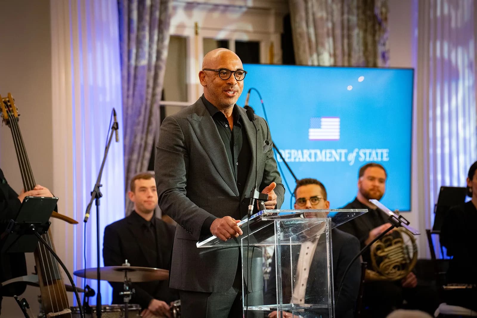 Harvey Mason Jr. speaks at a lectern during an event.