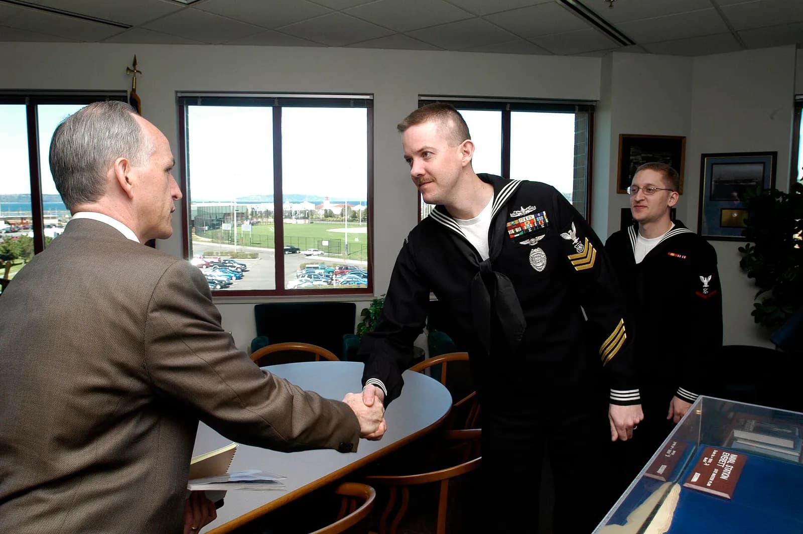 Rep. Adam Smith meets with two U.S. Navy service members aboard Naval Station Everett.