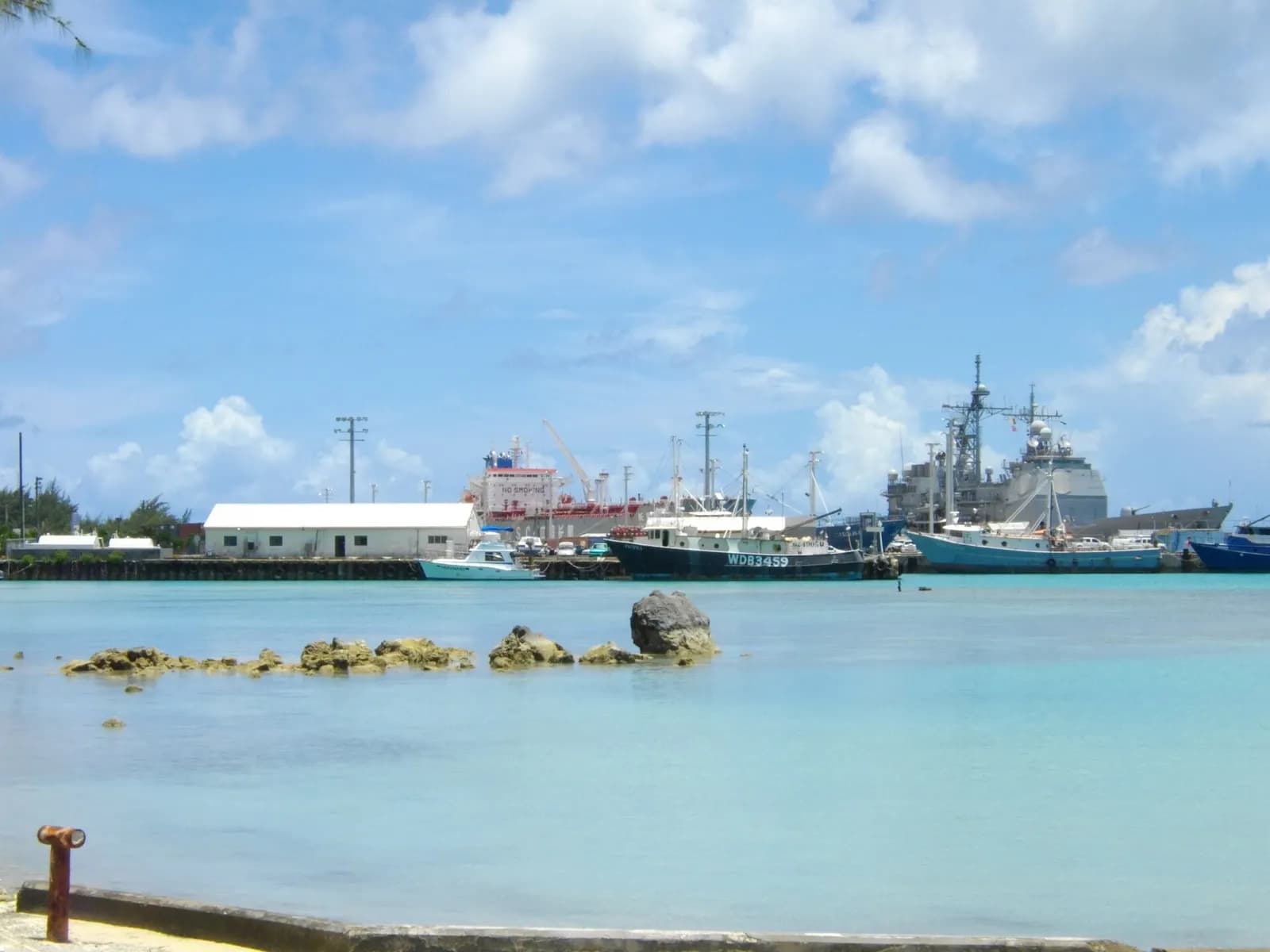 Boats and port facilities at Saipan harbor, seen across the water.