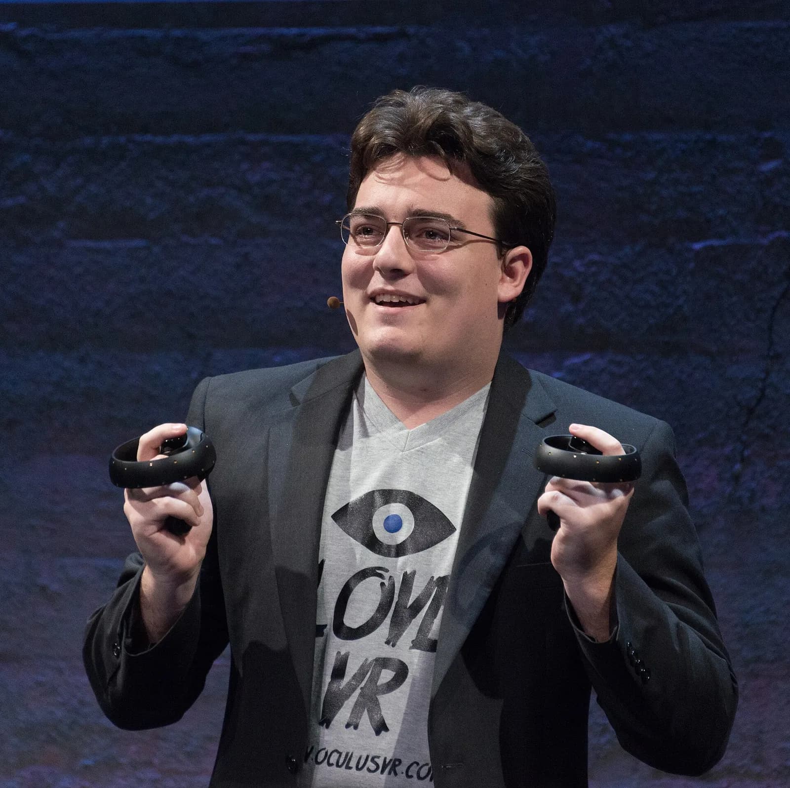 Palmer Luckey holds an Oculus Touch prototype at a 2015 event.