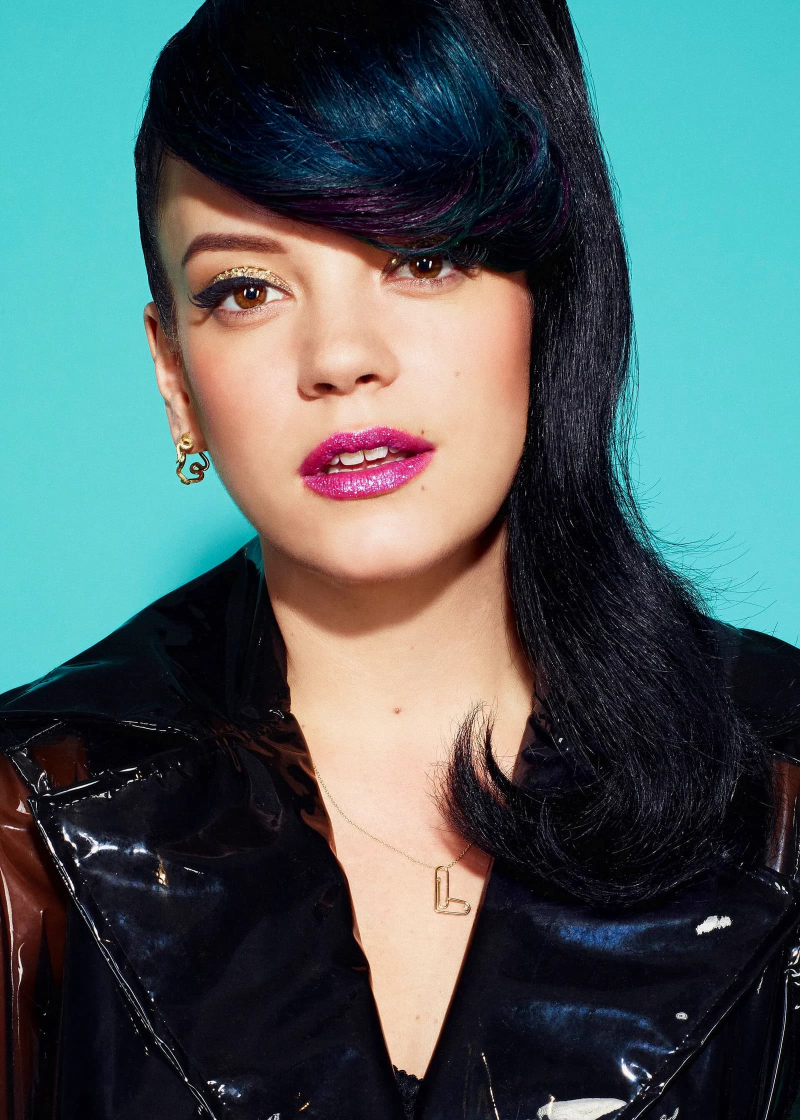 Portrait of singer Lily Allen against a blue background.