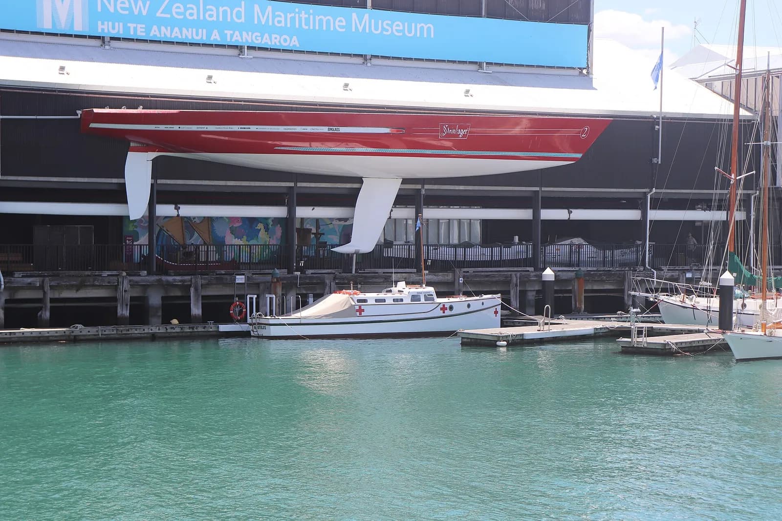 The Nautilus berthed at the New Zealand Maritime Museum, with the yacht Steinlager 2 above it.