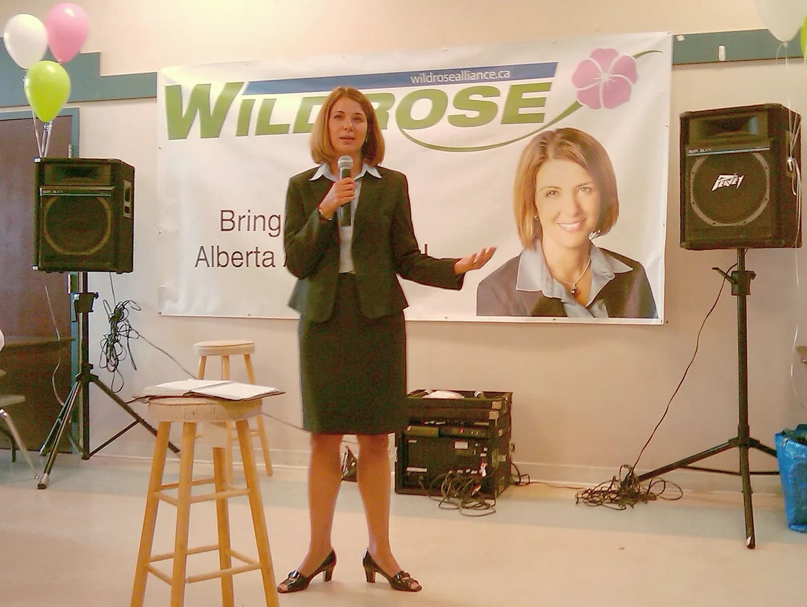 Danielle Smith speaks into a microphone at the Greenfield Community League in Edmonton.