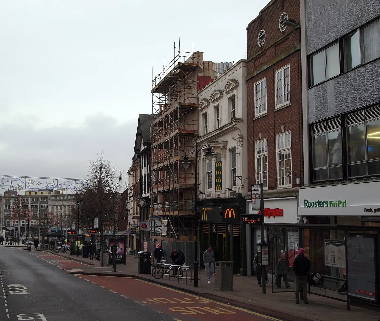 A street scene on Angel Row in Nottingham, with commercial buildings and roadworks.