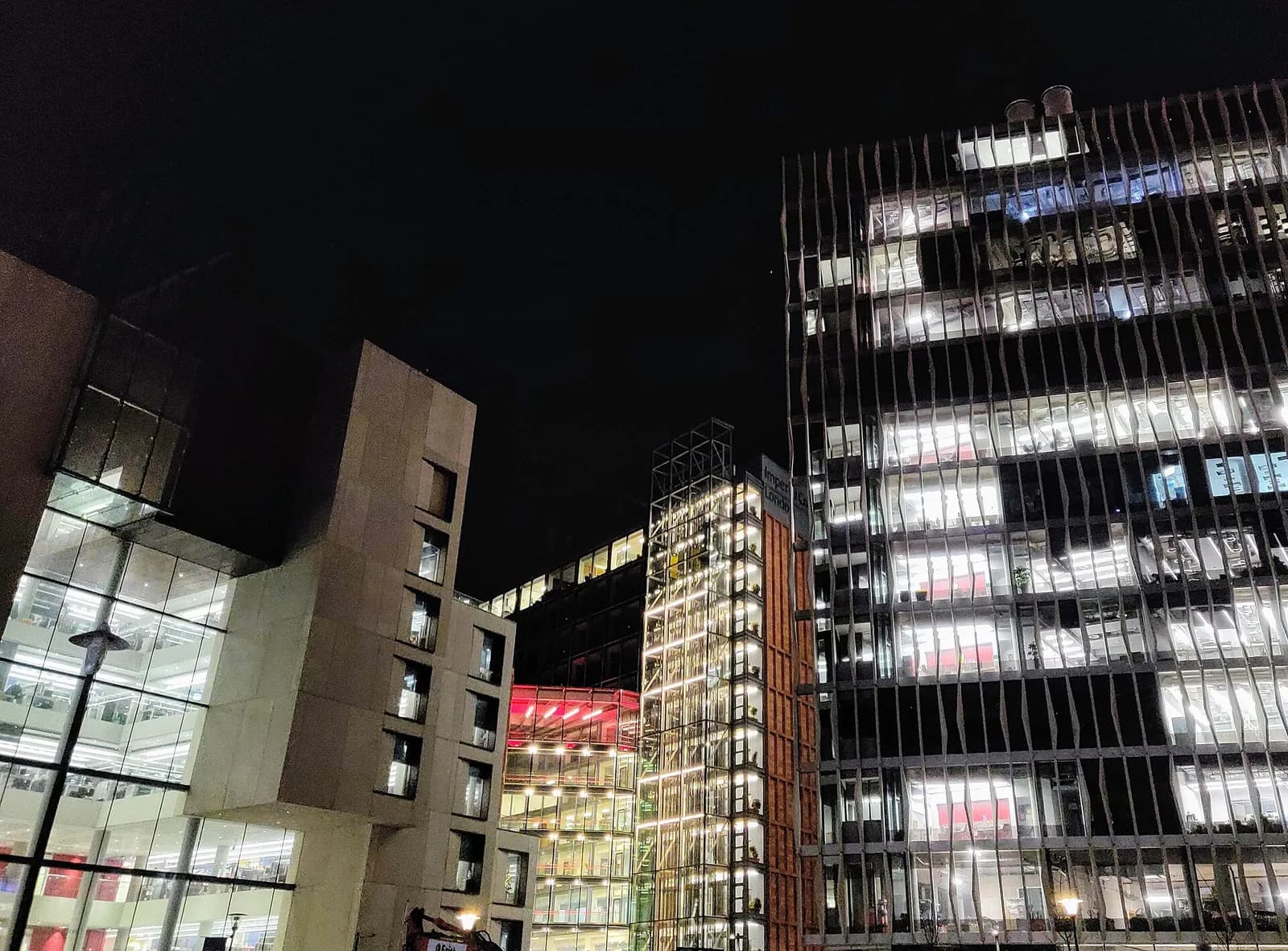 Research buildings on Imperial College London's White City campus illuminated at night.