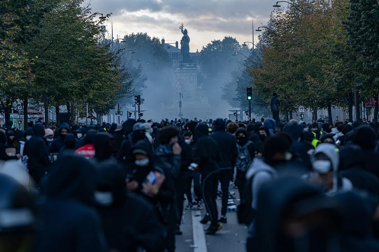 A crowd gathers near the Place de la République monument in Paris amid tear gas.