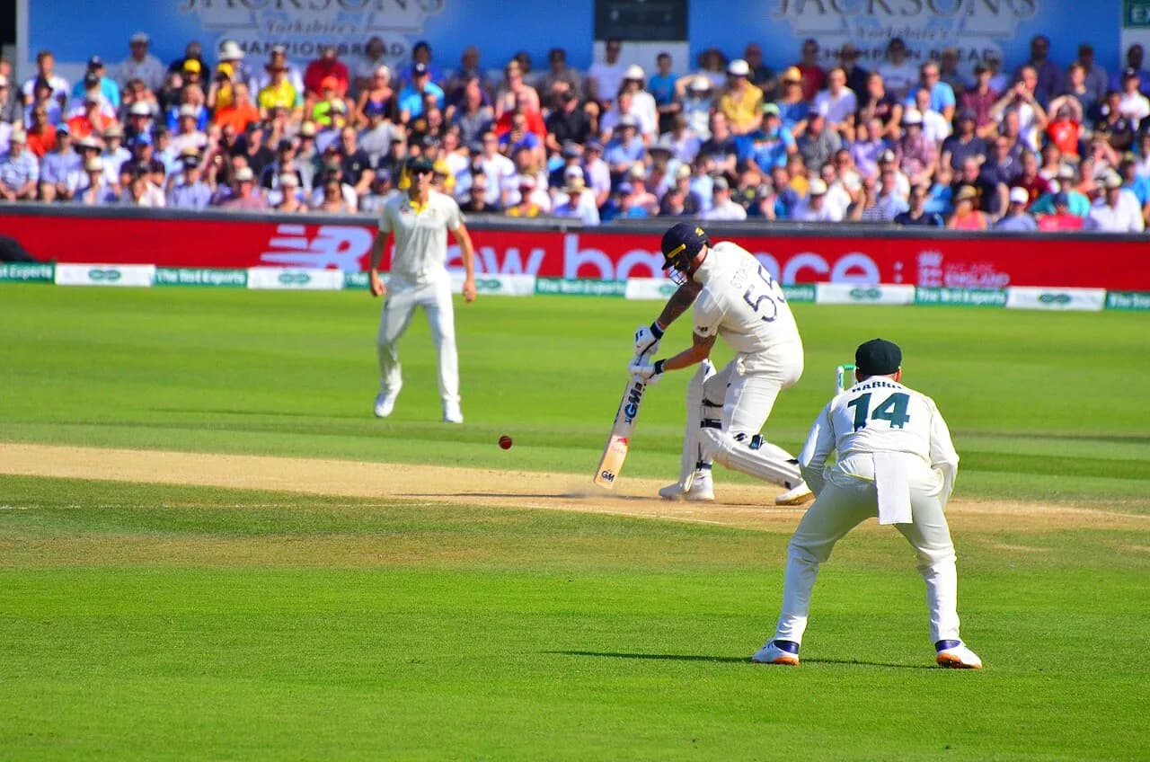 Ben Stokes batting for England as Marcus Harris watches in the field