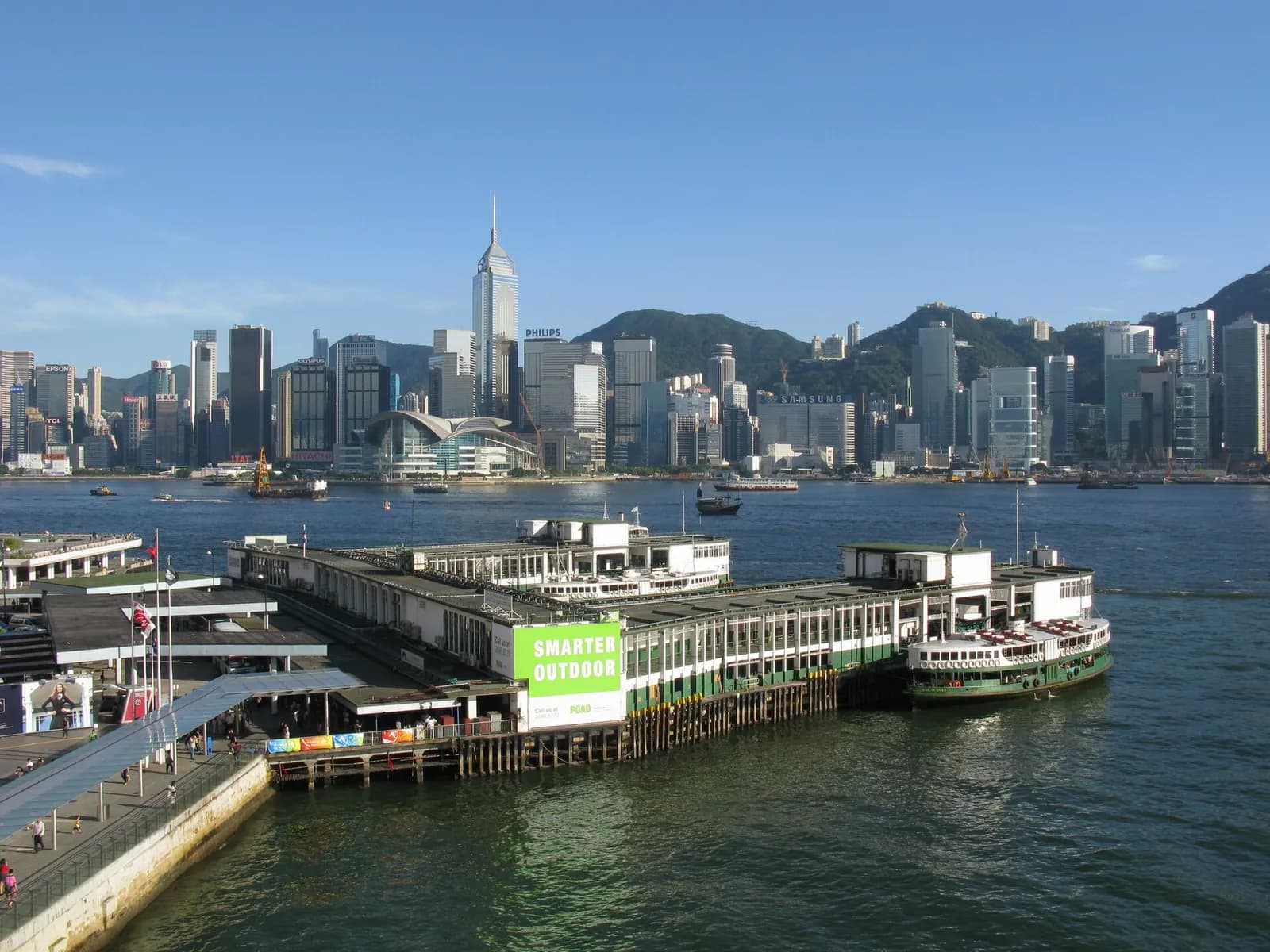 Tsim Sha Tsui Ferry Pier in Kowloon, with a Star Ferry vessel at the pier and Wan Chai across the bay.