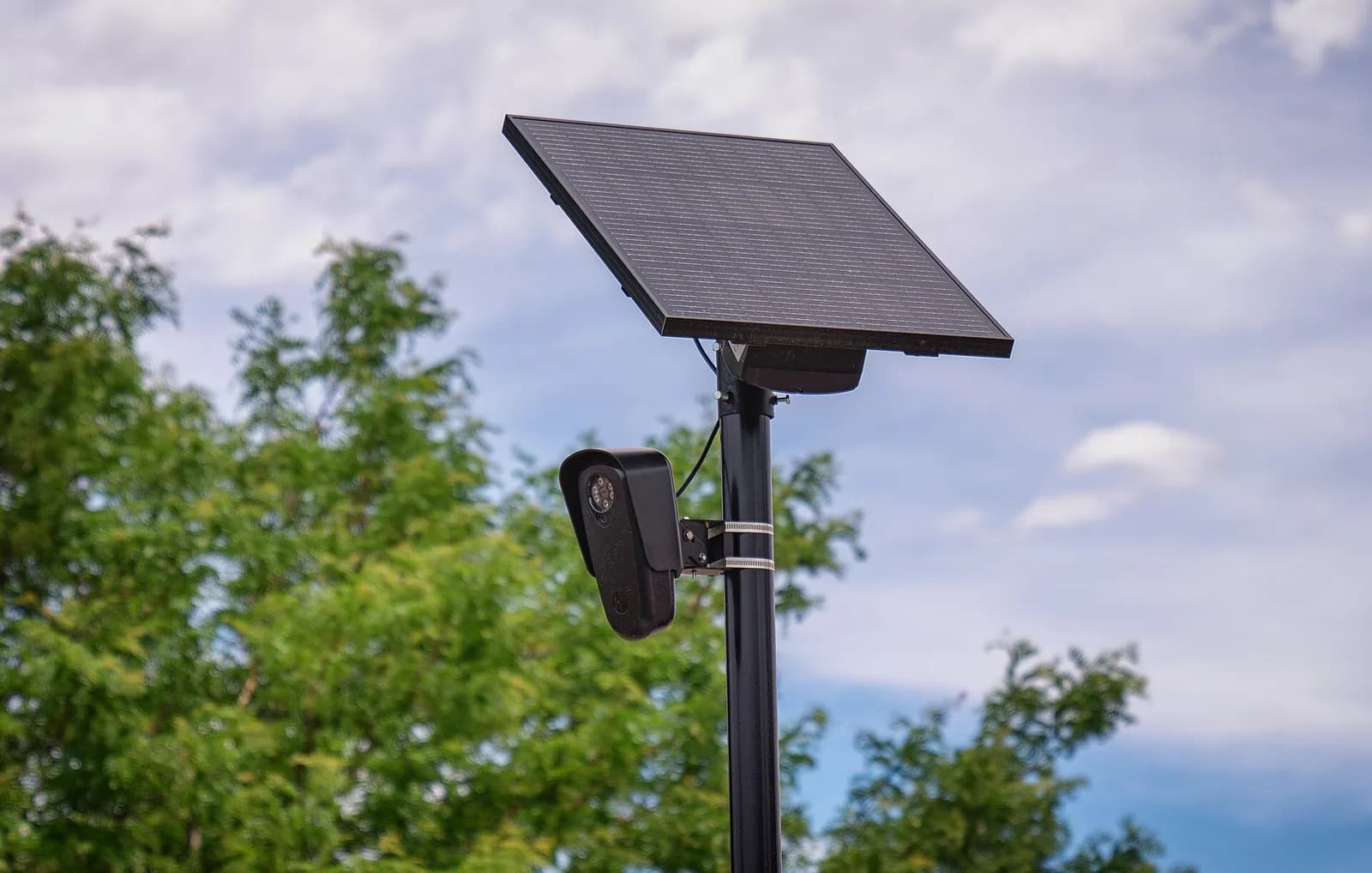 A Flock Safety automated license-plate reader camera mounted on a pole outside a retail store.